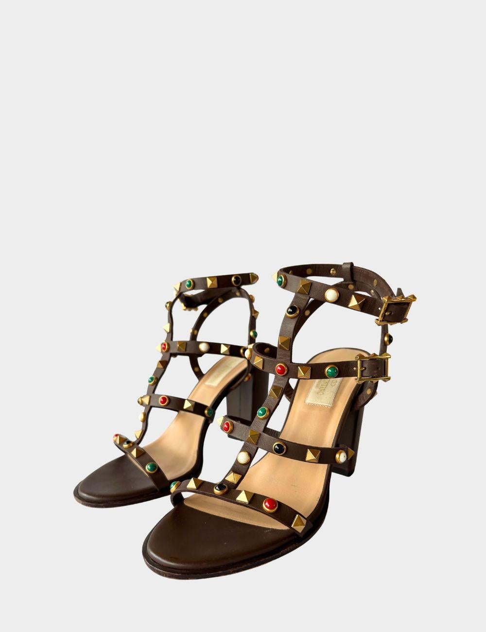 Elevate your footwear collection with these striking Valentino Rockstud sandals. Crafted from rich brown leather, these block heel sandals feature the iconic Rockstud embellishments combined with vibrant multicolor cabochon studs for a bold yet