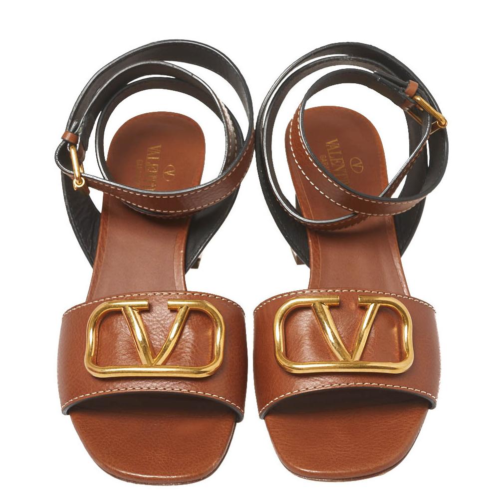 These brown sandals by Valentino are a high-end fashion pair you will love to own. Crafted from leather, they feature open toes, the signature V-logo detailed vamp straps, ankle wraps with buckle fastenings and 6 cm block heels.

Includes: Original
