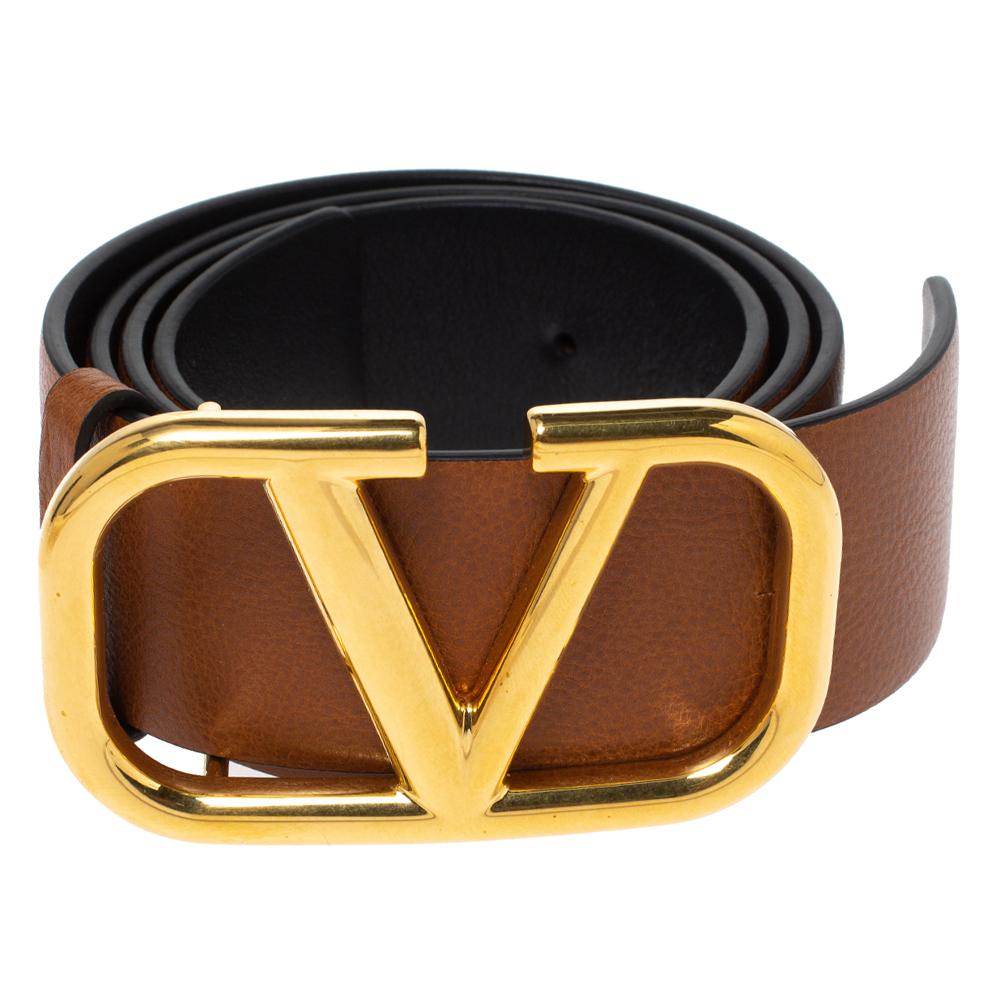 This sleek belt represents a statement style. Crafted with brown leather, the Valentino creation has the signature V buckle in gold-tone metal. It can be used to accessorize your everyday looks with a subtle touch of luxury.

Includes: Original