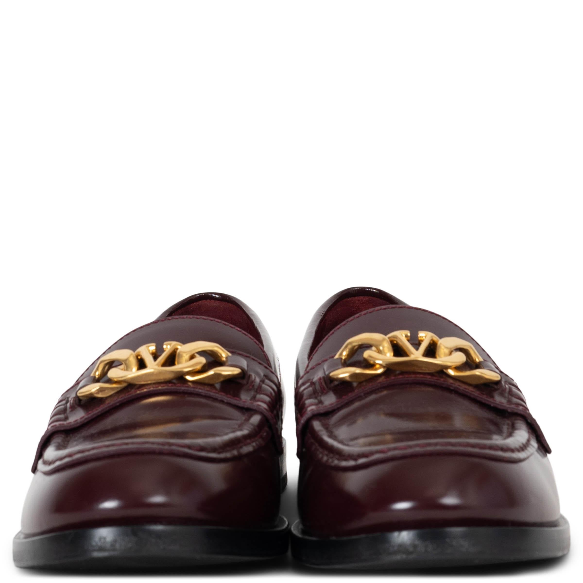 These 100% authentic Valentino loafers are crafted from burgundy smooth leather and feature a striking gold-tone Vlogo chain detail across the front. A timeless and elegant design, these loafers effortlessly combine sophistication with a modern