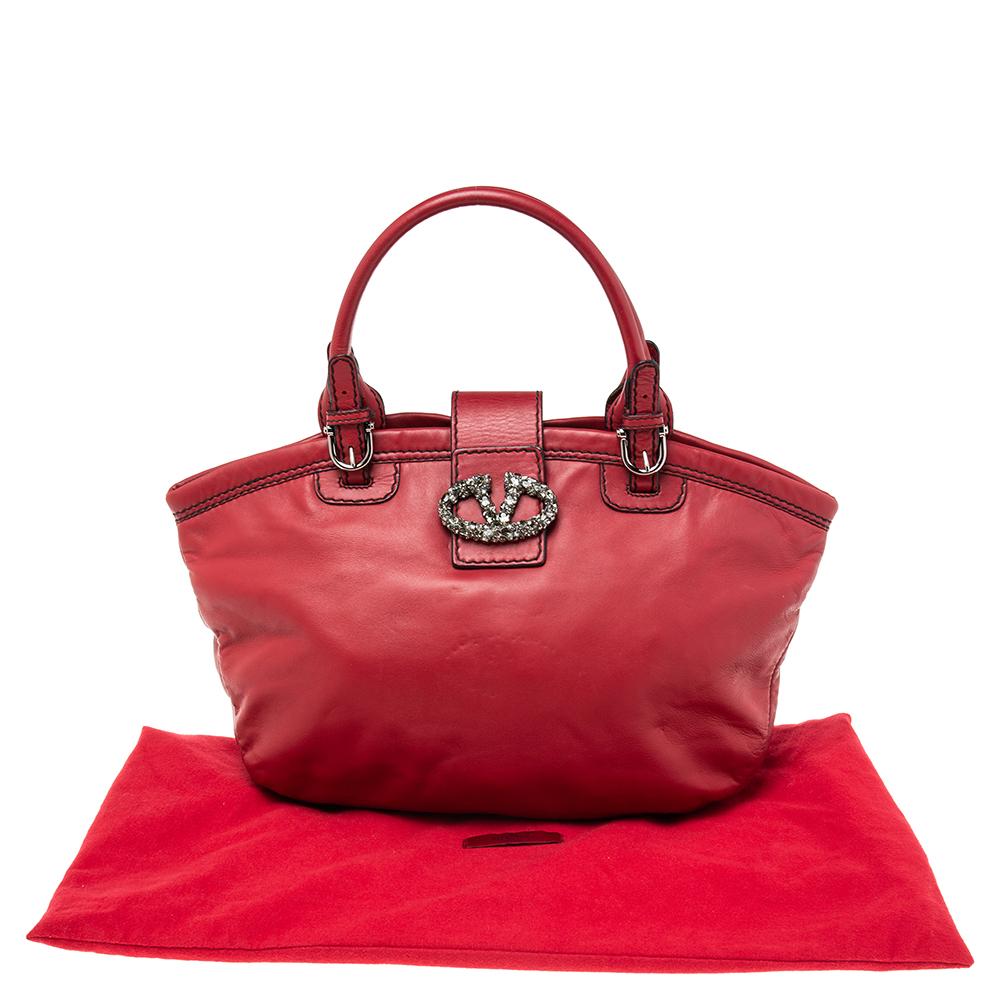 Valentino's burgundy leather bag is a beautifully sewn creation. The front flap is furnished with the label's iconic VLogo, elevated with jewels, and opens to reveal a satin interior. Carry it in your hand or hold it on the shoulder as an everyday