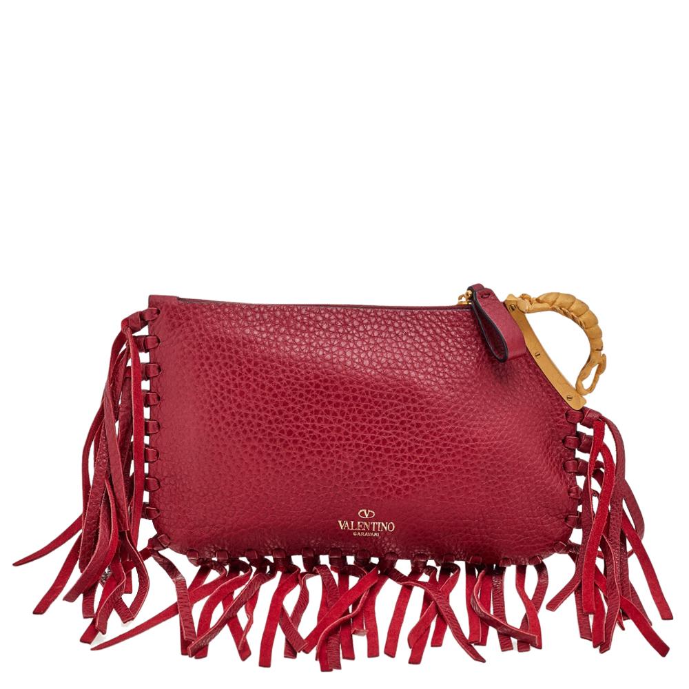 Crafted using leather, this Valentino clutch is added with knotted fringes along its edges, and a gold-tone gryphon detail on one side. The suede-lined interior is secured by a zip closure.

Includes: Info Booklet, Brand Tag