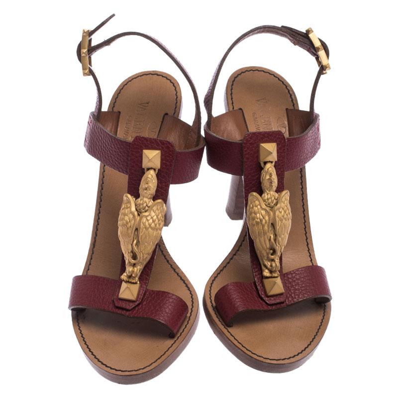 These Valentino sandals are gorgeous. Made from leather, they come with a gold-tone scarab detail on the burgundy T-strap, buckle ankle straps and 10 cm heels. The leather soles are highlighted with Valentino labels.

Includes: Original Dustbag

