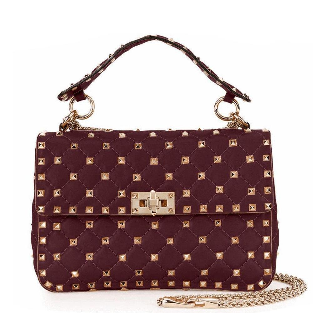Shoulder bag in burgundy. 
Signature pyramid stud detailing throughout. 
Detachable leather carry handle with spring-ring fastening. 
Detachable round curb chain shoulder strap with lanyard clasp fastening. 
Foldover flap with turn-lock fastening.