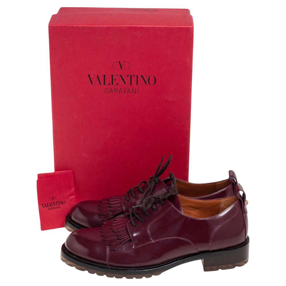 Complete a casual-chic look with these Valentino Derby shoes. Made from burgundy patent leather, they are added with lace-up closure and fringes on the uppers.

Includes: Info Booklet, Original Box