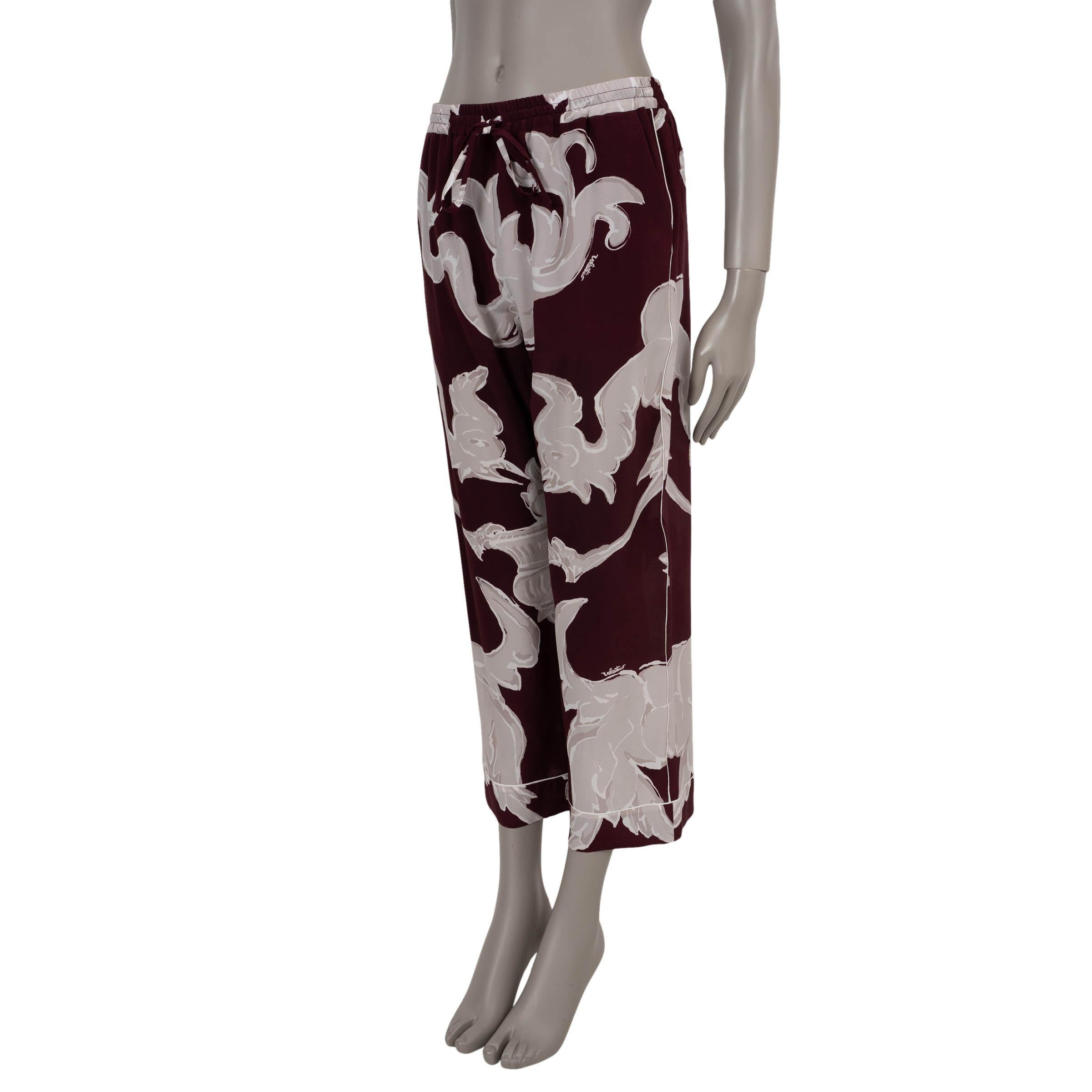 This 100% authentic Valentino pants in burgundy, taupe, and white Metamorphos Gryphos printed crêpe de chine silk (100% - please note the content tag is missing) exude refined loungewear elegance. Designed with a cropped, wide-leg silhouette, they