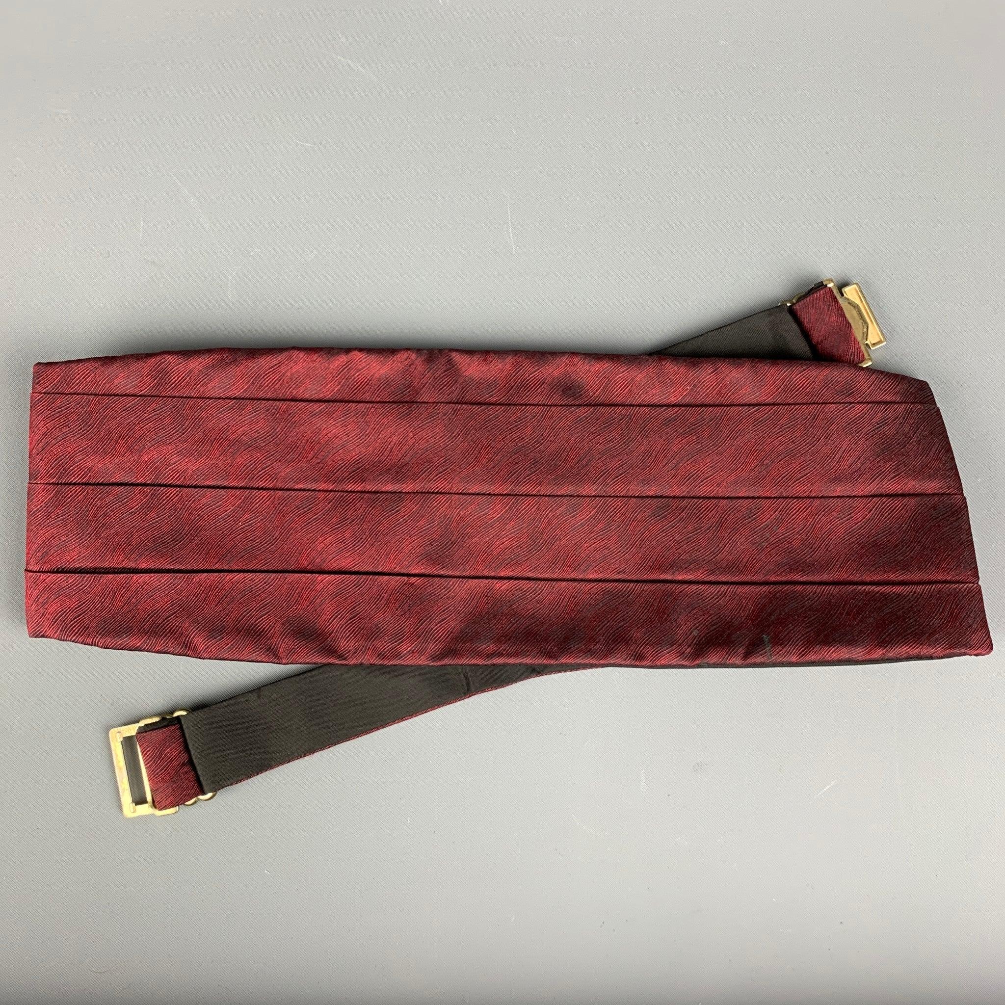 VALENTINO cummerbund in a burgundy texured silk featuring a buckle closure and matching pre-tied bow tie. Made in USA.Good Pre-Owned Condition. As is. 

Measurements: 
  - Cummerbund:Width: 4.5 inches Length: 39.75 inches  
- Bow Tie:Length: 18