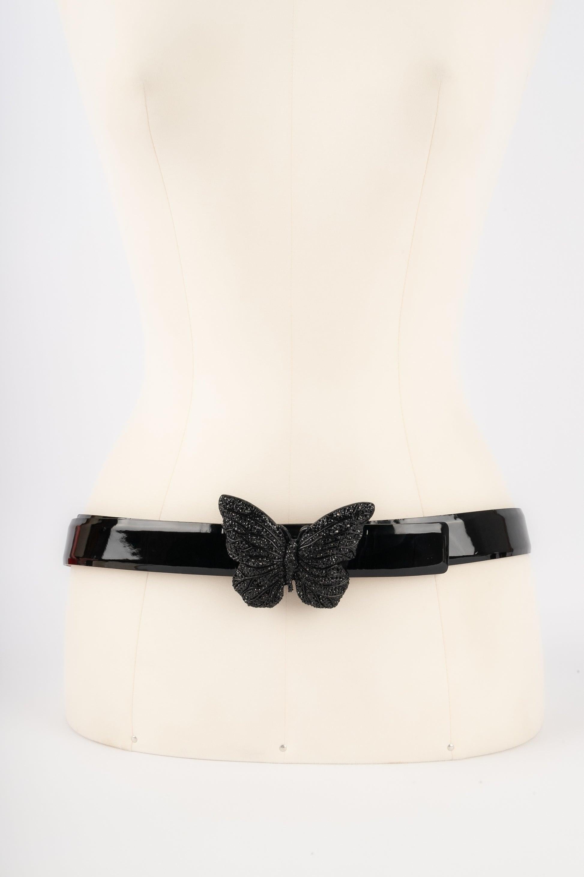 Valentino  - Black patent leather belt with a metal buckle representing a butterfly covered with black rhinestones.

Additional information:
Condition: Very good condition
Dimensions: Length: from 85 cm to 95 cm

Seller Reference: ACC163