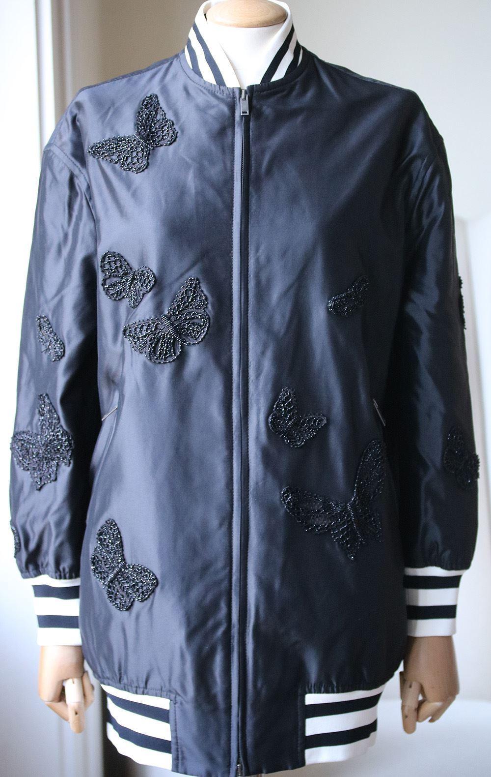 Bomber neck. Double-slider zipper clousure on front. Two zipped pockets on front. Ribbed edges. Butterfly crystals embroidery. Lined. 100% silk; lining: 100% polyamide.

Size: US 00 (UK 2, FR 30, IT 34)

Condition: As new condition, no sign of wear. 