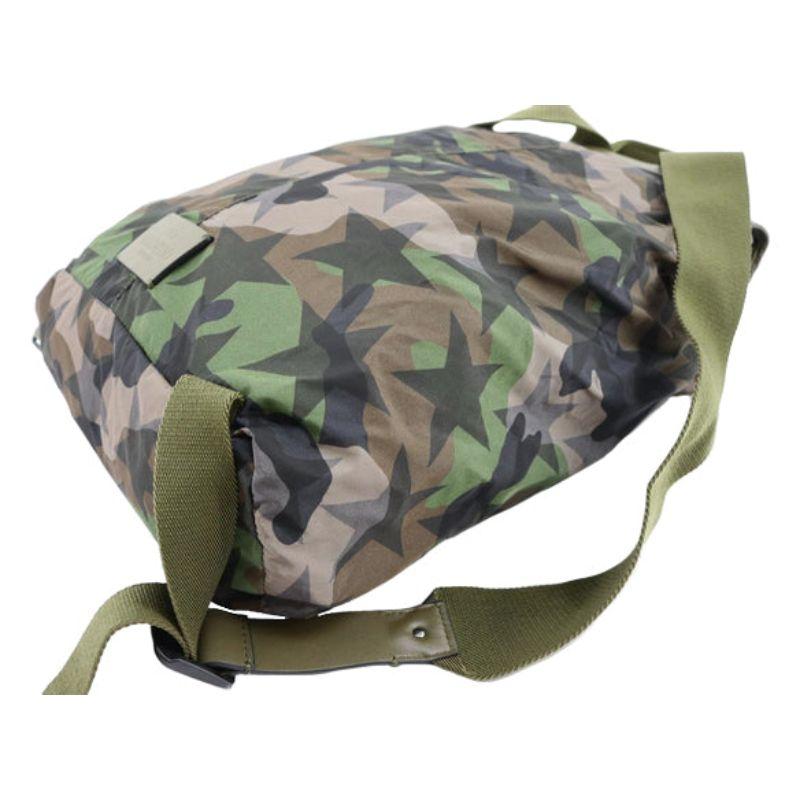 Valentino Camustars backpack features green Camouflage and black stars printed nylon, double adjustable shoulder straps, single top handle, front flap with buckle closure, drawstring closure under front flap, front zip pocket, green canvas lining