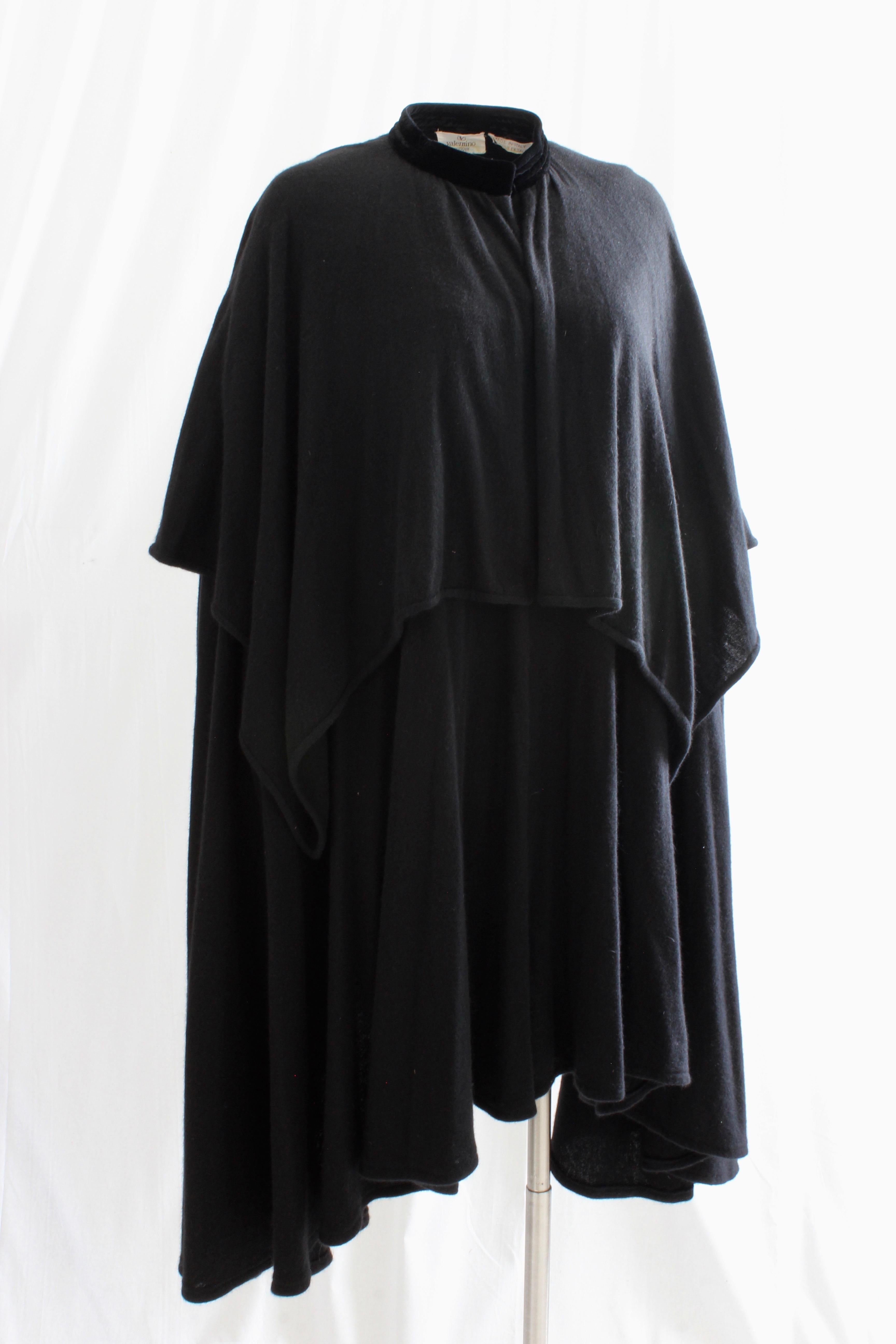This gorgeous cape was made by Valentino, most likely in the early 1980s.  Made from what we believe is an angora wool blend knit (no content label) in black, it's incredibly soft, features a tiered caplet and fastens with two hook/eye closures at
