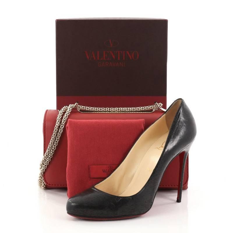 This authentic Valentino Cash and Rocket Shoulder Bag Leather Medium is part of a collaboration with Julie Brangstrup's charity supporting the empowerment of women and children in third world countries. Crafted in red leather, this compact bag