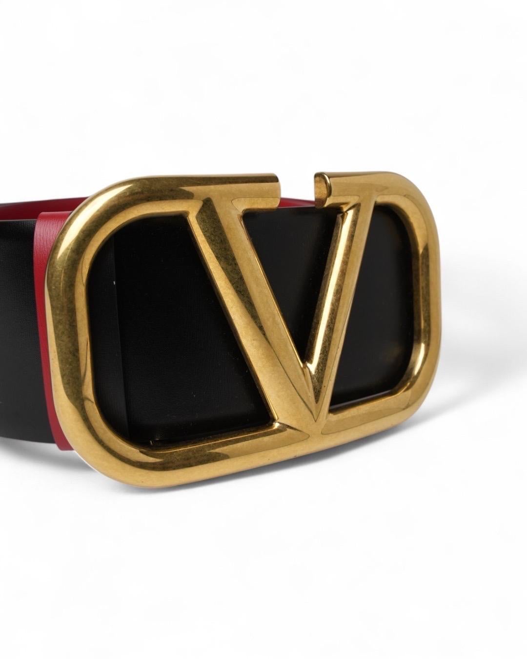 Cintura firmada Valentino, realizada en piel lisa en elegantes tonos negro y rosa. Está dotada de una fibra metálica con el clásico logotipo de la marca 