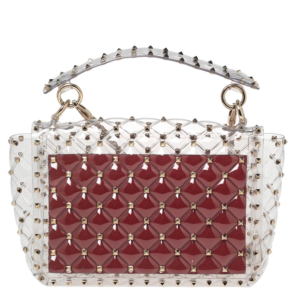 This Rockstud Spike bag from Valentino brings a blend of fine craftsmanship and limitless style. The PVC bag has a shoulder chain and a see-through design. It features the iconic Rockstud details and the front flap opens to a roomy interior where