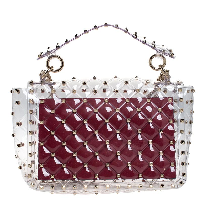 Stylish and elegant, this is the accessory that makes a fashionista stop and admire. The classic design is crafted in Italy and comes in quilted, clear PVC with a top handle and multiple gold-tone Rockstuds over the body, which is the signature of