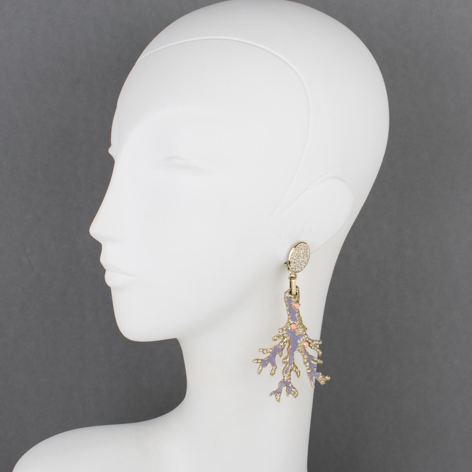 These mesmerizing Valentino Garavani jeweled clip-on earrings boast a pale gilded metal branch shape ornate with faux-coral glass rhinestone cabochons and purple lavender enamel. The fastenings of the earrings have an oval shape and are all covered