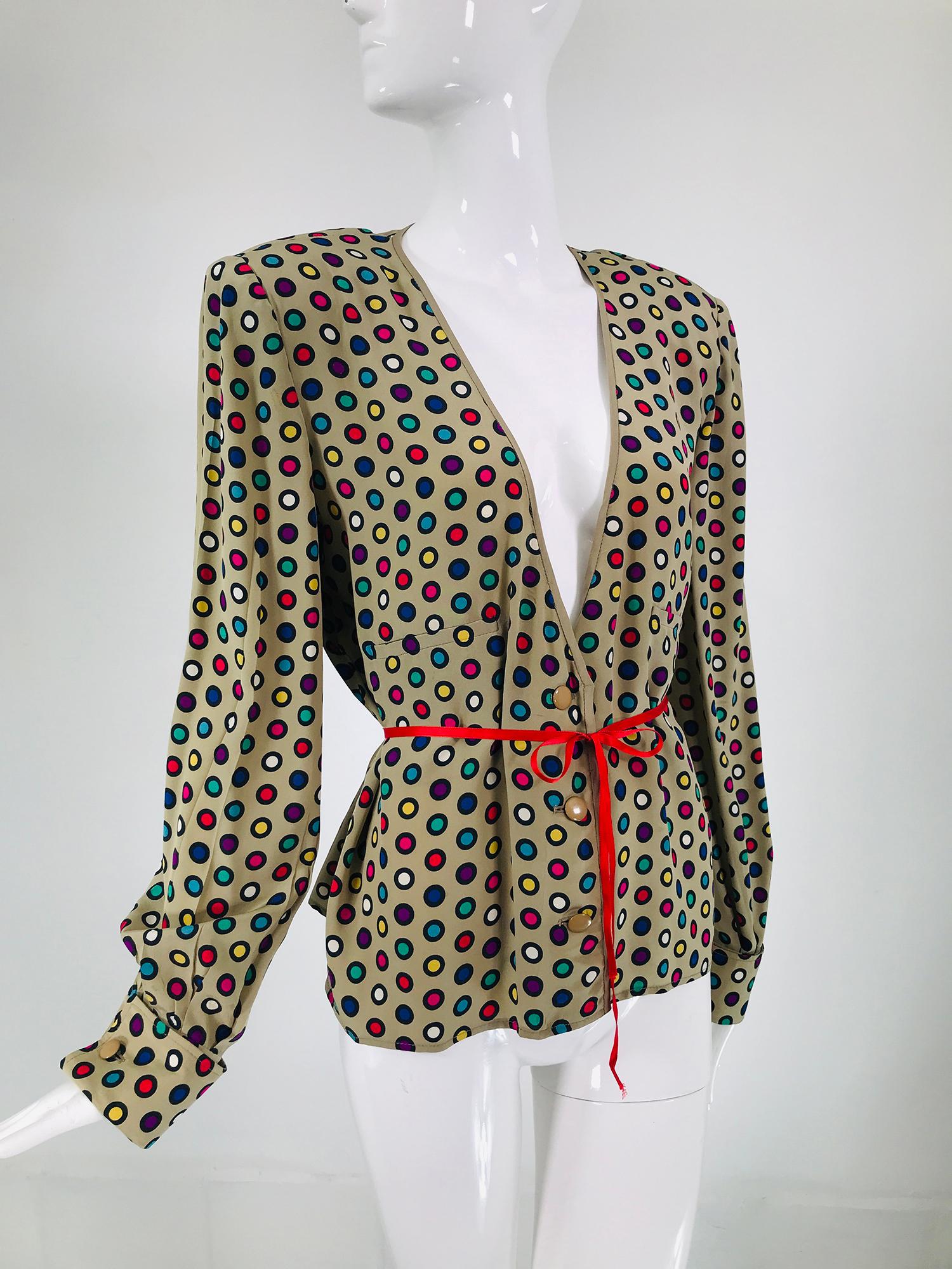 Valentino coloured circles silk V neck, button front jacket from the 1980s. Taupe ground with black ring circles of red, yellow, aqua, white, blue & fuchsia. The long sleeves have shoulder pads, the sleeves are gathered into french cuffs. There are