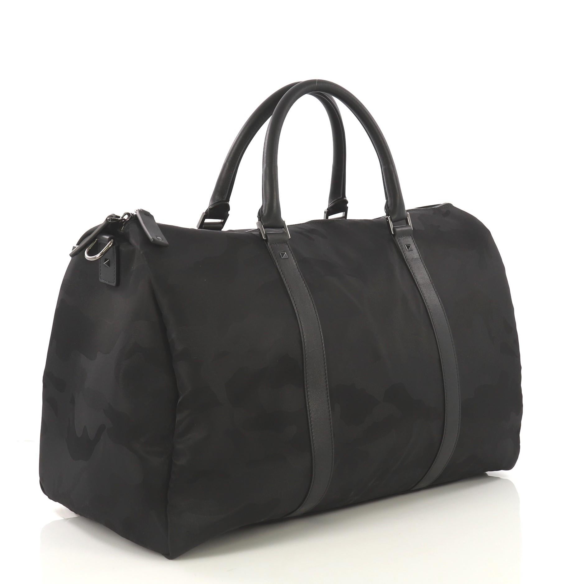This Valentino Convertible Weekender Bag Camo Nylon Large, crafted from black camo nylon, features dual rolled leather handles, protective base studs, and black-tone hardware. Its zip closure opens to a black nylon interior. 

Estimated Retail