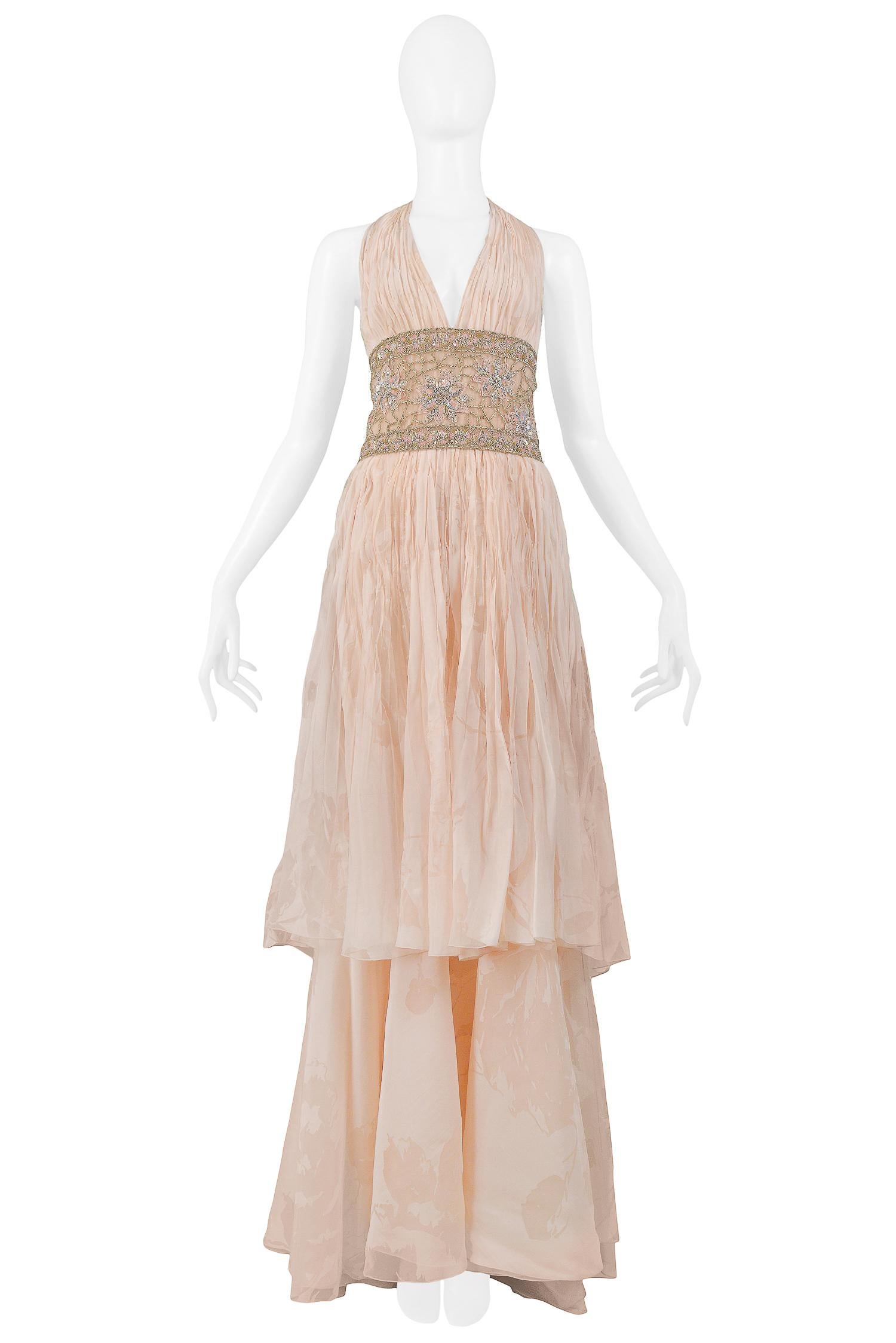 We are excited to offer a vintage Valentino peach pink floral silk runway gown. The gown is 100% silk and features a halter style V-neckline with accordion pleating,  two-tiered skirt, slight train, a side zip closure, and a handmade gold and silver