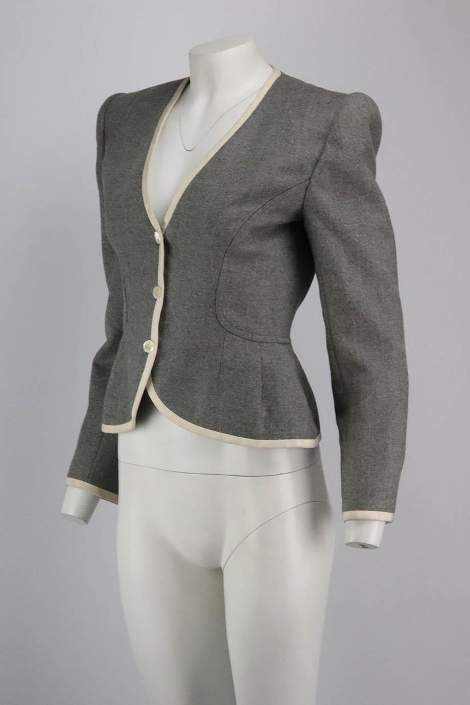 This blazer by Valentino Couture has been tailored in Italy from exceptionally soft wool and has strong padded shoulders and a sweeping v-neckline, trimmed in ivory grosgrain. Grey wool, ivory grosgrain. Button fastening at front. Size: Small (UK 8,