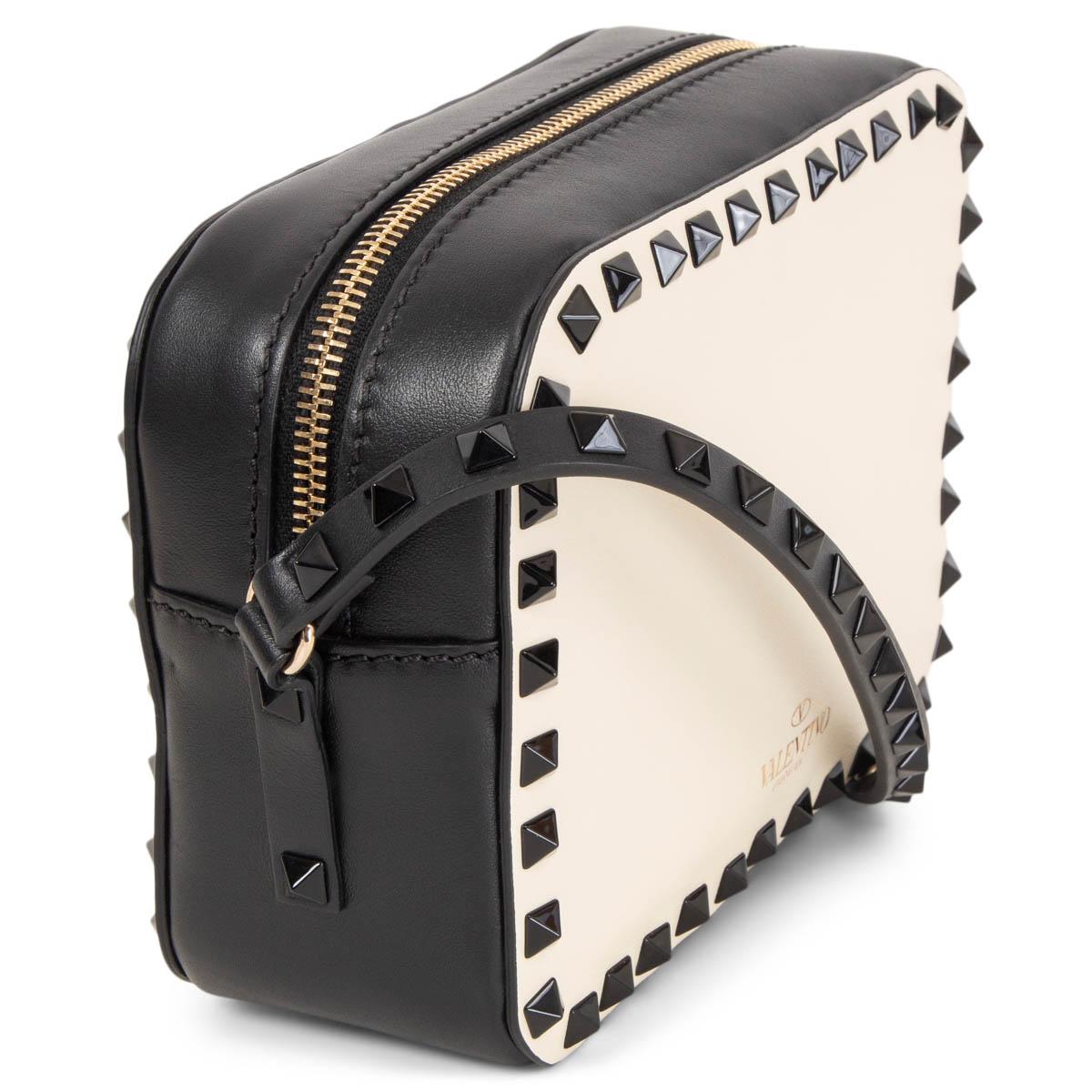 100% authentic Valentino Rockstud Camera Bag in black and cream smooth leather embellished with black classic pyramid studs. Opens with a zipper on top and is lined in black leather with one open pocket agaist the back. Brand new. Comes with dust