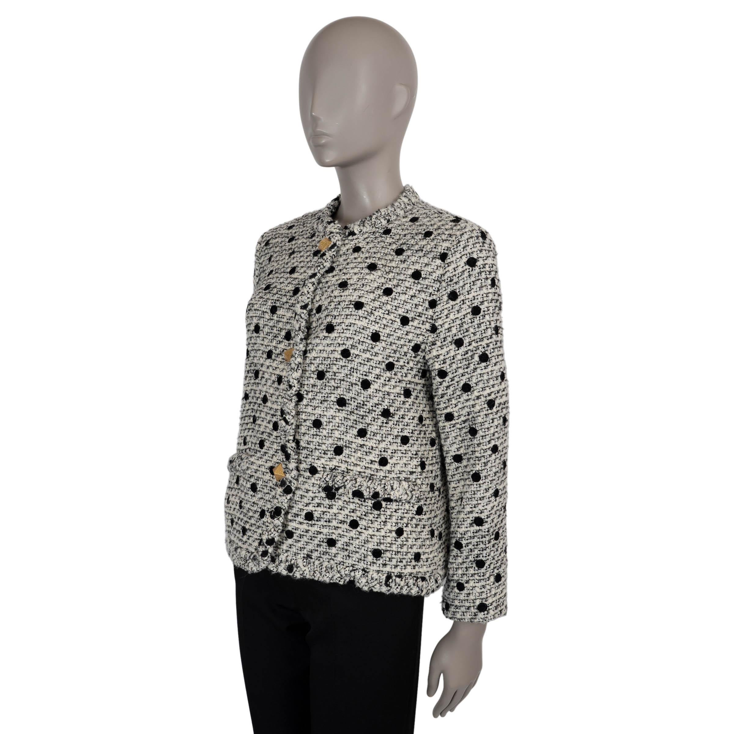 Questa giacca 100% autentica di Valentino è realizzata in tweed floccato a pois crema e nero composto da lana (65%), acrilico (26%), poliammide (5%) e poliestere (4%). Presenta una silhouette leggermente ampia, senza colletto, con scollo rotondo,