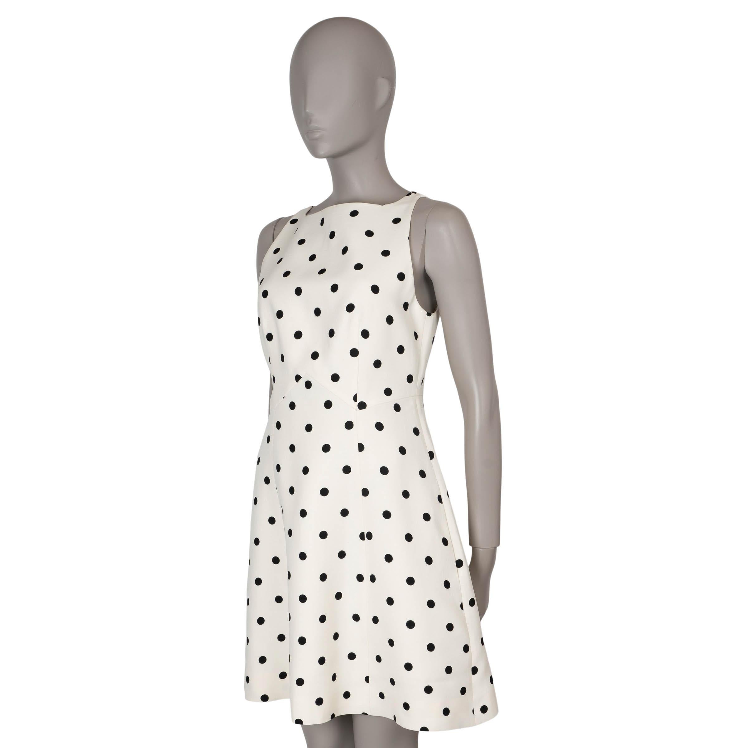 This 100% authentic Valentino mini dress in cream and black polka dot wool (65%) and silk (35%) offers timeless elegance with a playful touch. It features a crewneck, short sleeves, and a flattering flared skirt. The dress opens with a concealed