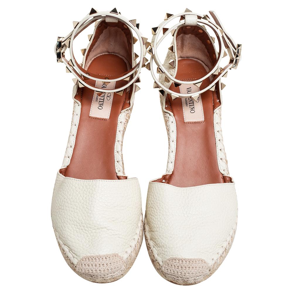 Designed especially for fashion queens like you, these Valentino espadrille sandals are leather-made and breathtakingly gorgeous! They come flaunting ankle straps, jute braided wedge heels, and their signature Rockstud accents adorned on the ankle