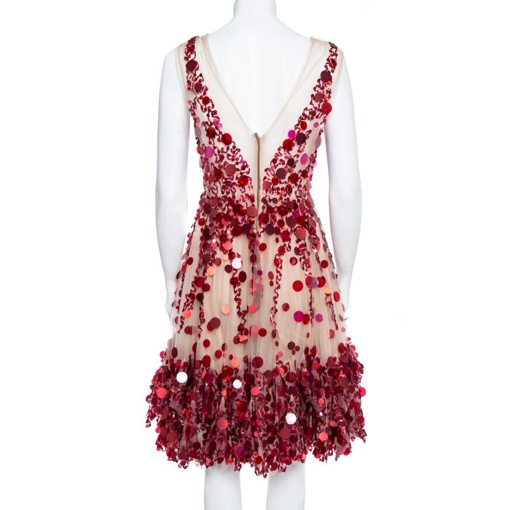 Extravagance meets great tailoring in this breathtaking dress from Valentino. In a feminine silhouette, it has a cream tulle body encrusted with an array of paillettes. The dress is fitted around the waistline then flared and has a plunging