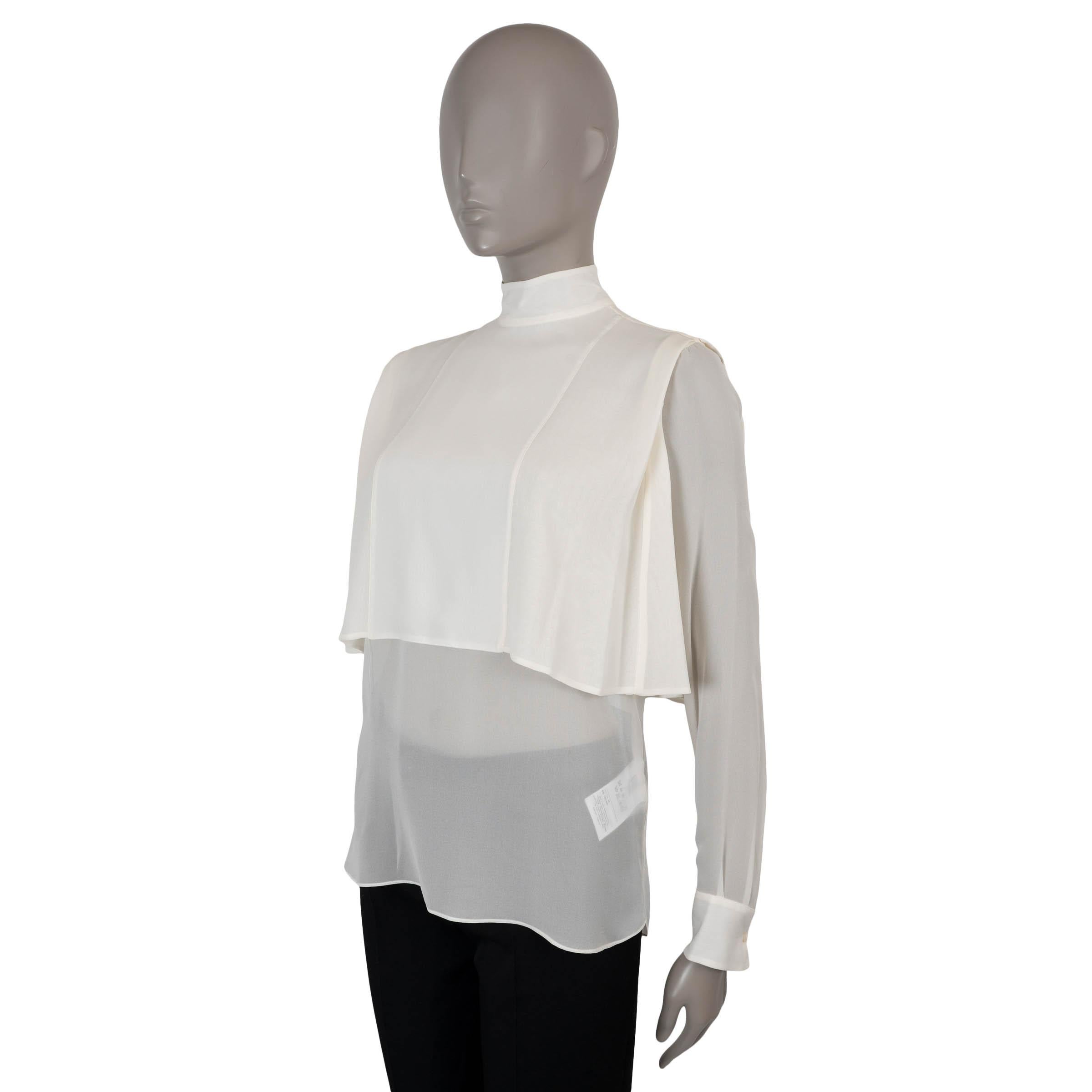Cette blouse Valentino 100% authentique est confectionnée en crêpe de chine de soie crème semi-transparent (100%), offrant un équilibre raffiné entre douceur et structure. Il présente une silhouette fluide et féminine avec un col simili et une