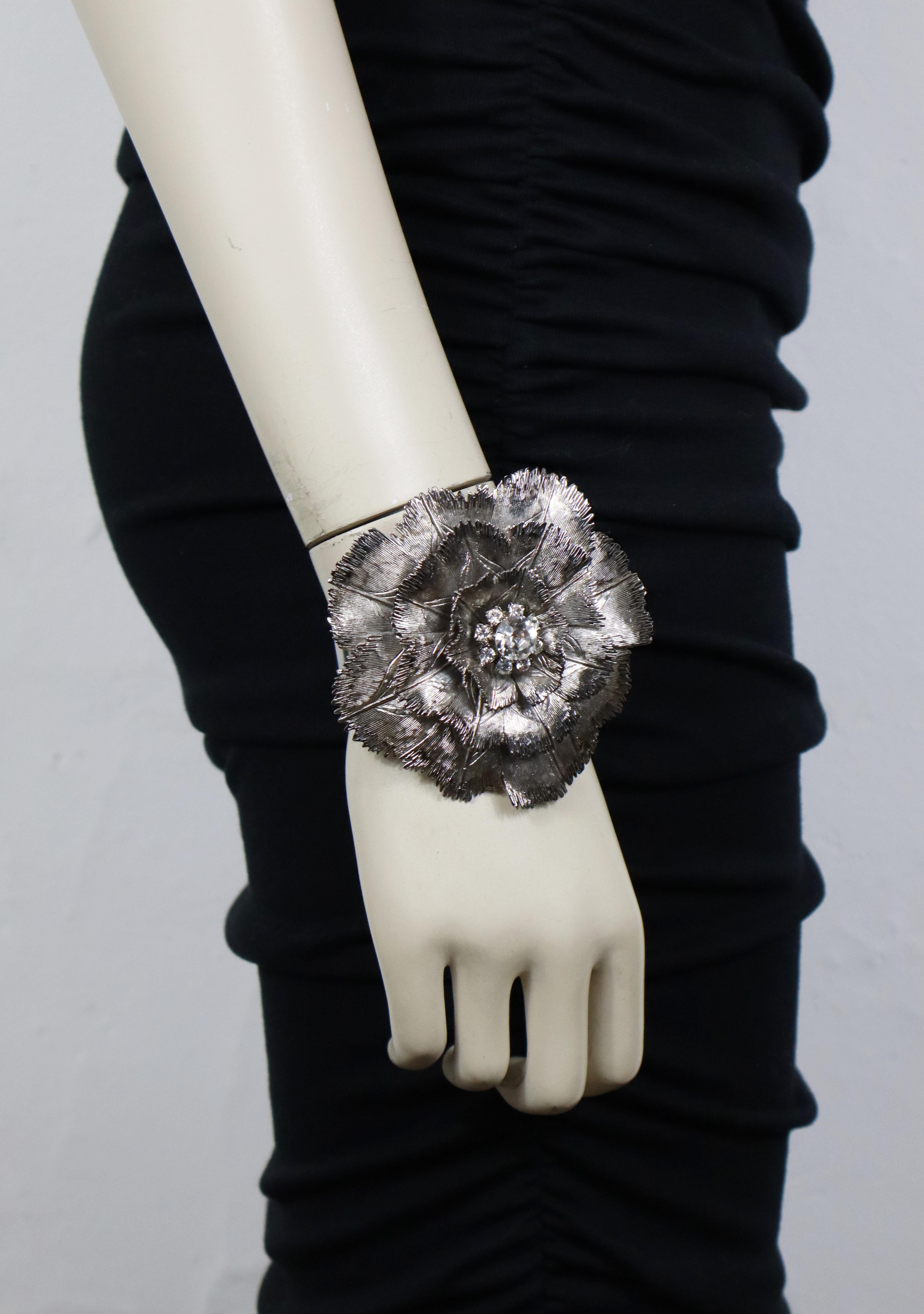 Bracciale Valentino con un grande fiore in argento anticato impreziosito da cristalli trasparenti.

Valentino Garavani in rilievo.
Prodotto in Italia.

Misure indicative: circonferenza interna circa 17,91 cm (7,05 pollici) / fiore circa 8,2 x 8,4 cm