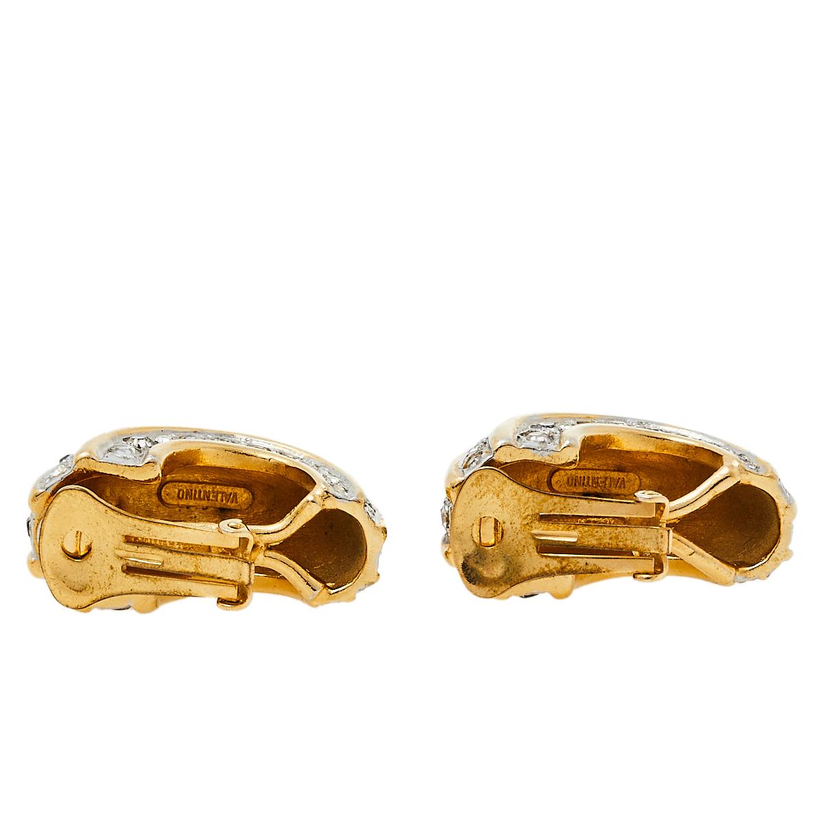 These Valentino earrings embody modern-day glamour in an elegant style. This luxurious gold-tone pair showcases crystal embellishments and is designed with a versatile clip-on style. It is finished with hallmark engravings on the inside.

