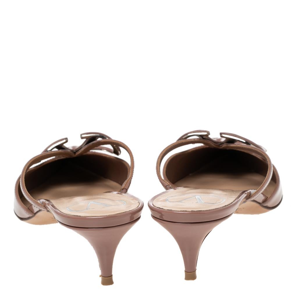 These stunning mules showcase Valentino's feminine sensibilities and elegant aesthetics. Crafted in Italy from patent leather, the pointed-toe silhouette is augmented by the VLogo Signature motifs exuding an opulent appeal. The mules are elevated on