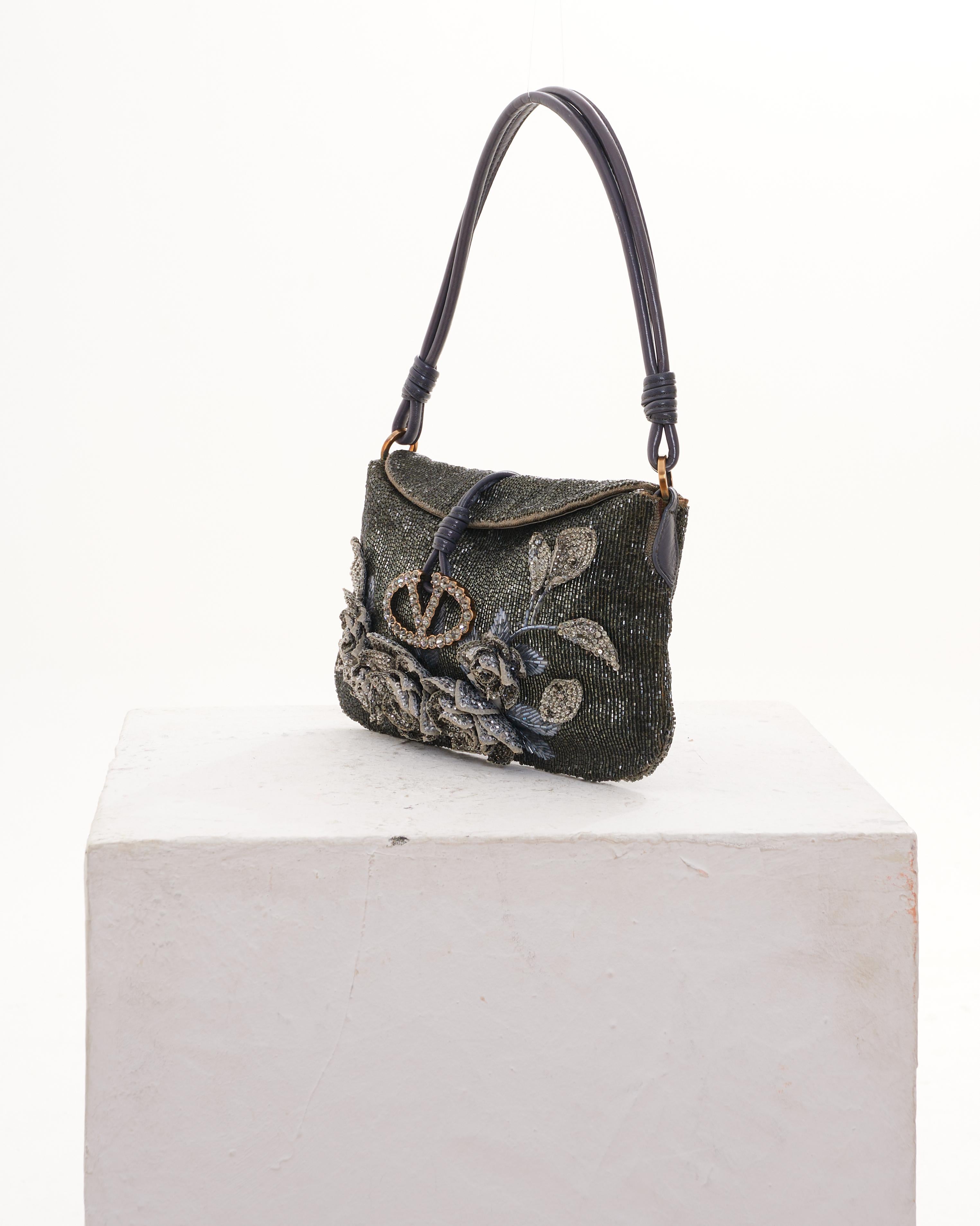 - Designed by Valentino Garavani
- Sold by Skof.Archive
-Early 2000s
- Grey Beaded and Embroidered Satin Flap Evening Bag
- Features exquisite pale dark gray satin exterior with beading allover
- Flowers are embroidered on the front, back and flap
-