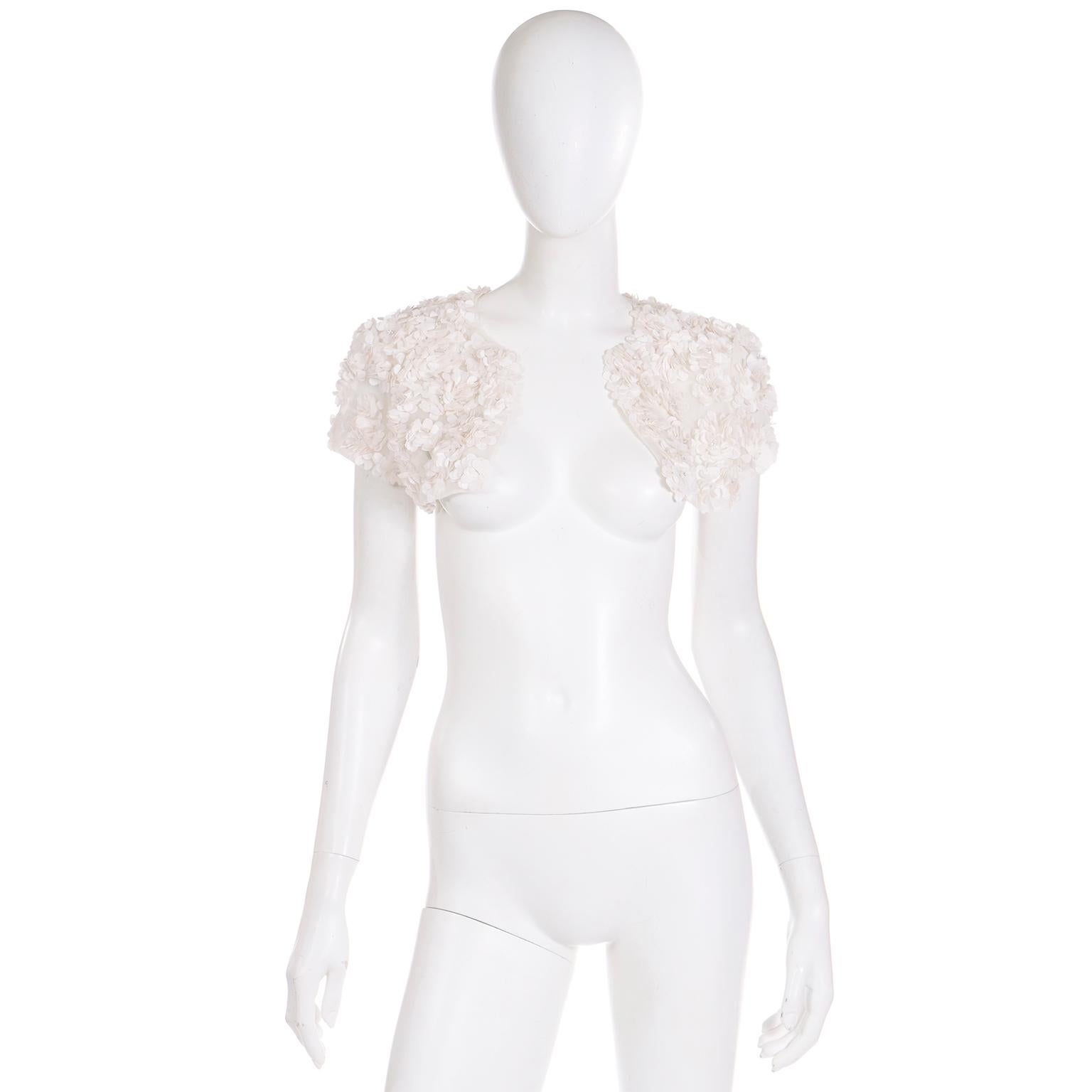 This is a such a truly special Valentino 2000's ivory silk cropped shrug style bolero jacket with pretty white floral appliques and small beads throughout. We love the attention to detail in Valentino Garavani pieces and this one has light sage