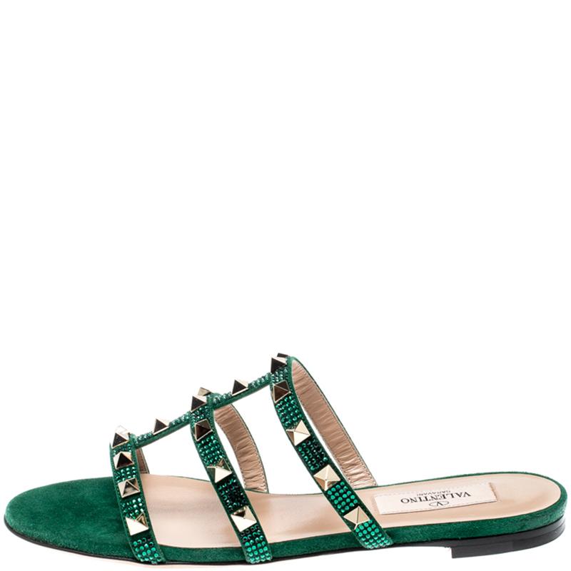 These Valentino slides feature a gorgeous emerald suede body that comes with straps on the top and detailed with the signature Rockstuds. Easy to slide it on and off, these pair makes a great accompaniment to dresses and skirts alike. Style with a