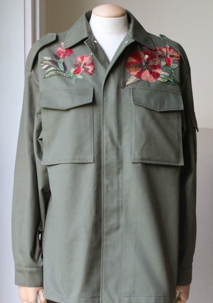 Long sleeve safari utility jacket in green. Embroidered floral pattern on the front and a sunset design on the back. Spread collar. Flap pockets at chest. Adjustable cinch-straps at sleeve cuffs with Velcro fastening. Made in Italy. 100% Cotton.