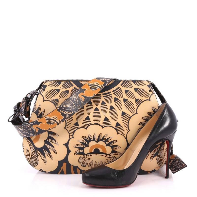 This authentic Valentino Floral Shoulder Bag Printed Leather Medium encapsulates retro-chic flower power style made for today's fashionista. Crafted in stand-out brown and black floral print leather, this stunning bag features an adjustable leather