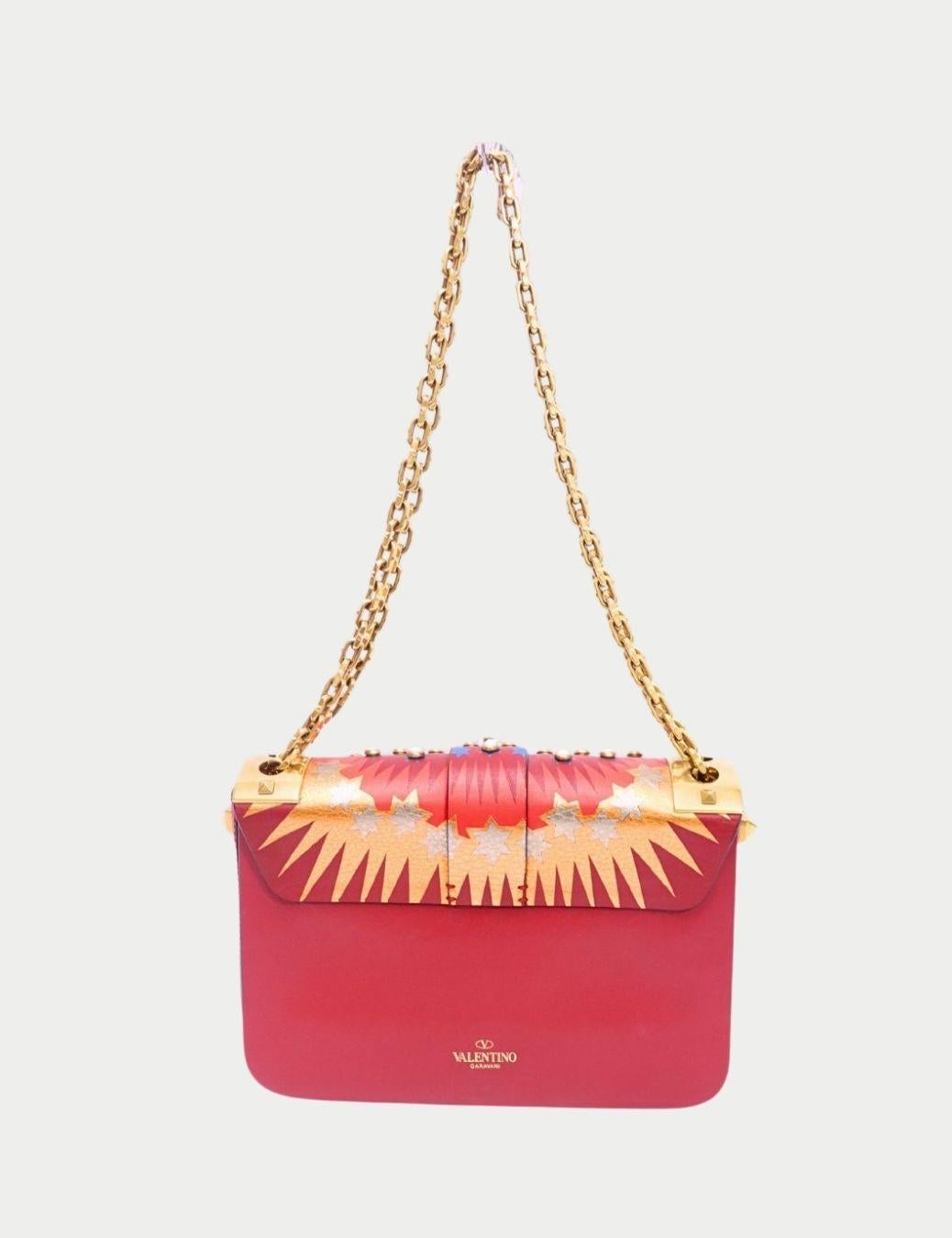 Faites-vous remarquer avec ce sac à bandoulière imprimé rouge Valentino Garavani, une création audacieuse qui allie l'art et le luxe. Confectionné en cuir de première qualité, il présente un imprimé vibrant inspiré des rayons du soleil, rehaussé de