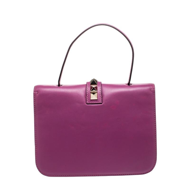 If you are looking for a bag with a blend of modern style and class, this Valentino creation is the answer. Crafted from leather, this purple piece comes with a flat top handle and a flap with a push-lock to secure the well-sized fabric interior.