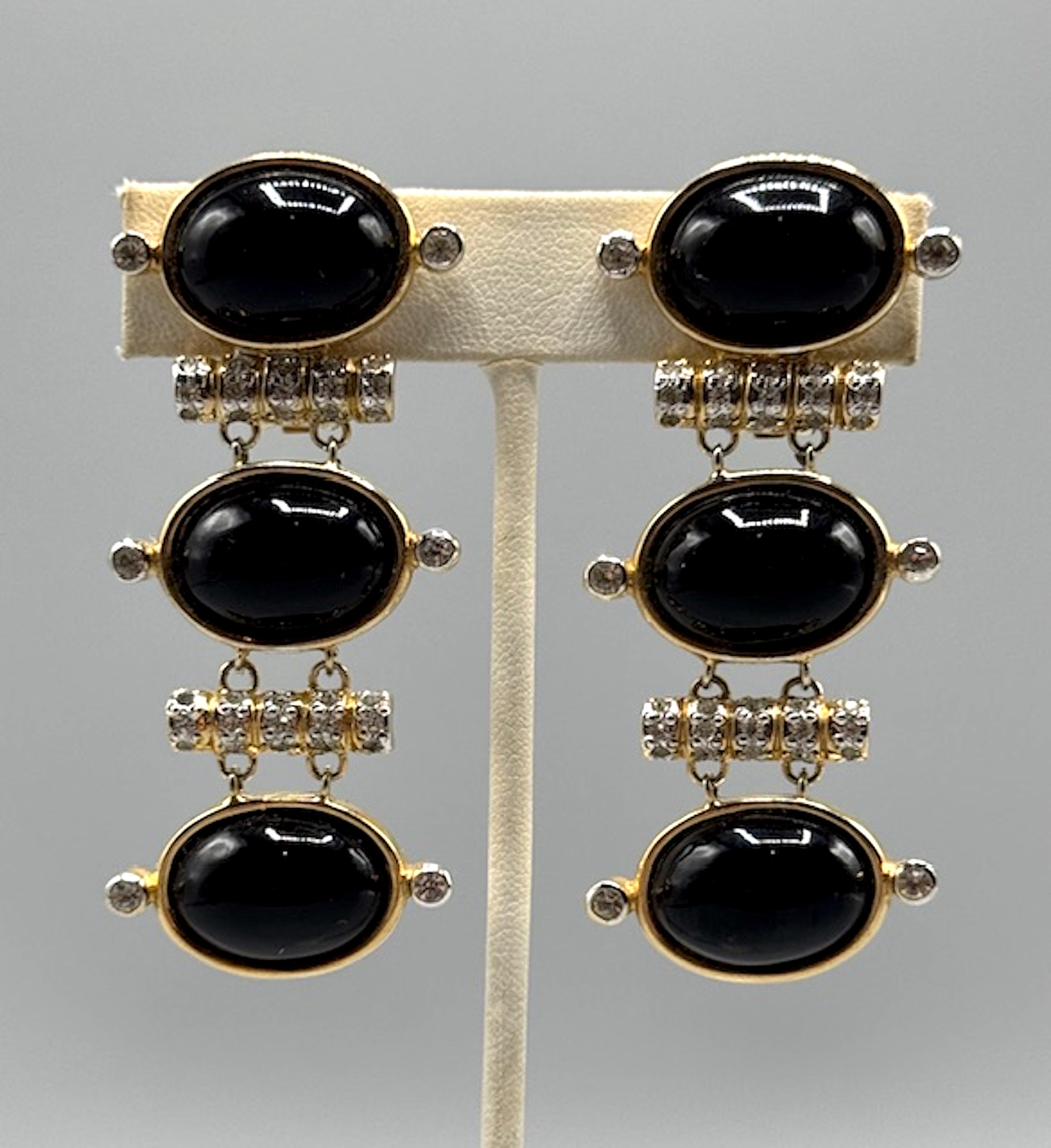 These vintage 1980s Valentino Garavani clip earrings exude timeless elegance and luxurious design. Measuring 1.13 inches in width and 2.5 inches in length, they feature a striking combination of gold-toned metal adorned with dazzling rhinestones.