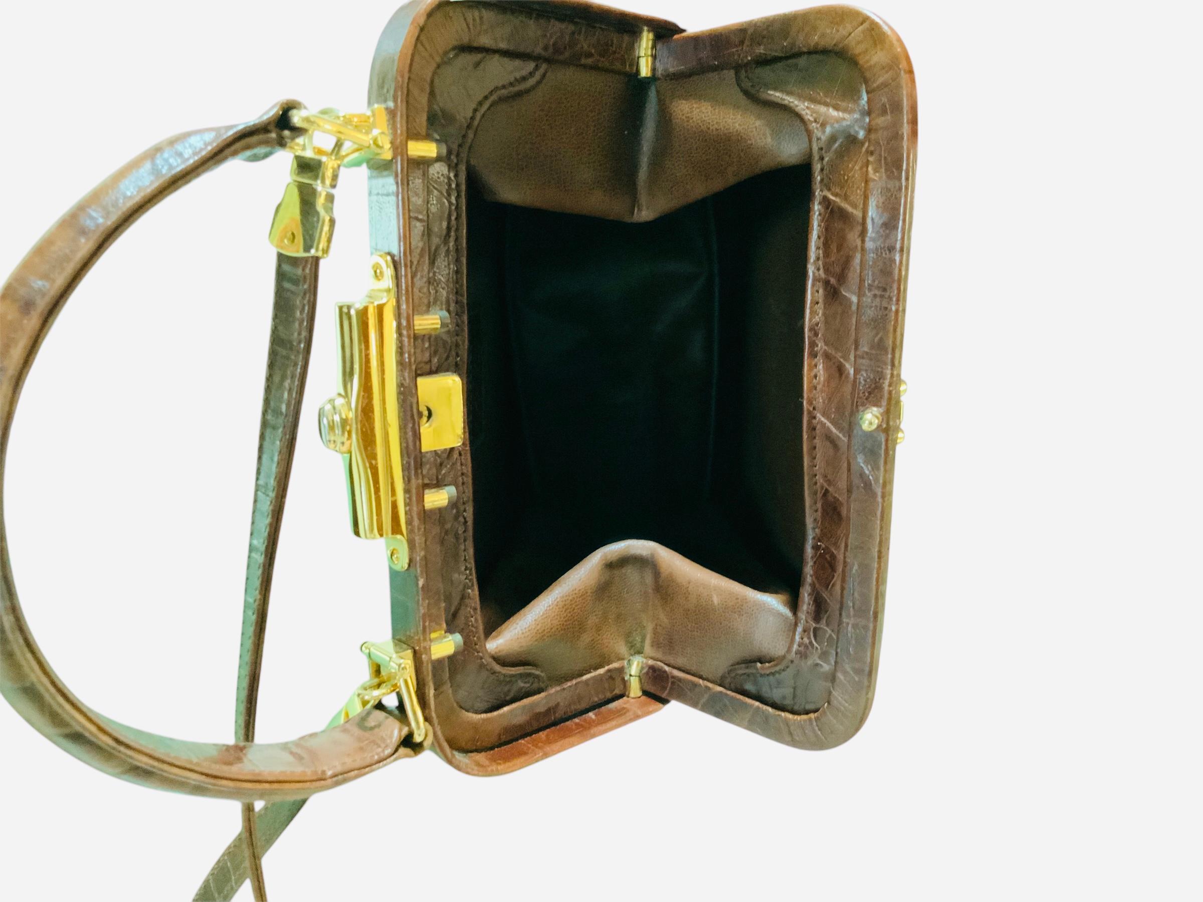 Questa è una borsa da collezione di Valentino Garavani in pelle di alligatore. Raffigura un borsellino in pelle marrone scuro a forma di trapezio con una tasca rettangolare nella parte anteriore con chiusura a scatto, ornato da due manici a goccia