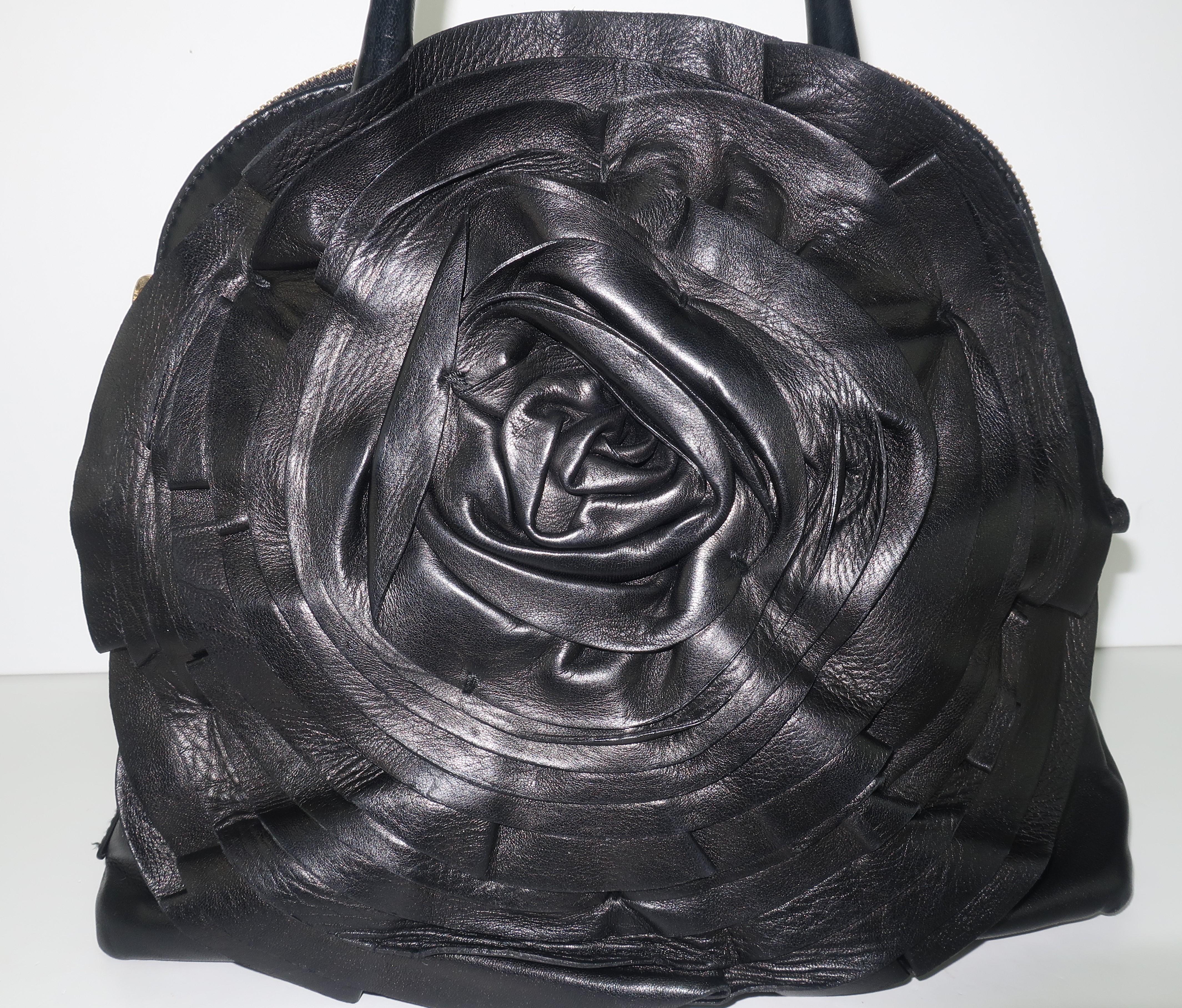 Beautiful Valentino Garavani black nappa leather handbag in a bowler style silhouette with a large rosette adorning one side.  The handbag offers double zipper closure, double top handles and a detachable shoulder strap.  The roomy interior is lined