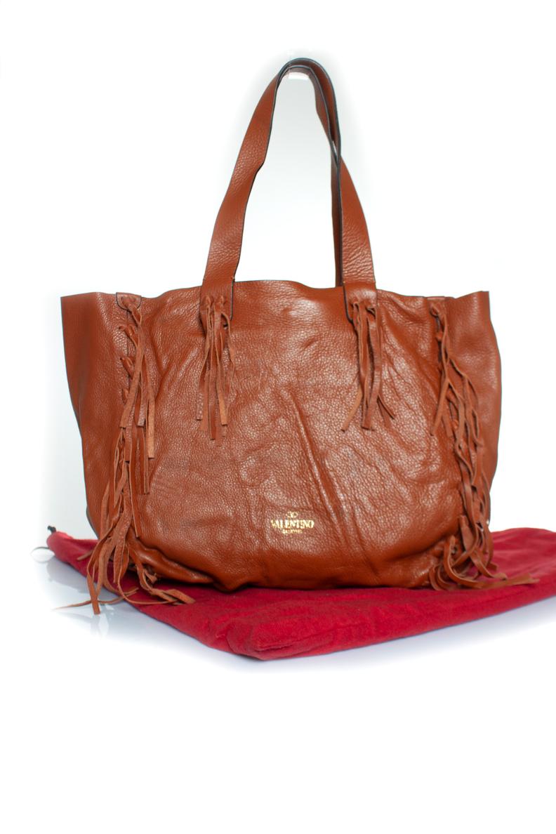 Valentino Garavani, C-Rockee fringed leather tote in brown. The item is in good condition with some small stains on the leather. Comes with dustbag.

CONDITION: good condition

MEASUREMENTS: height 34 cm, width 37 cm, depth 10 cm, height handle 24