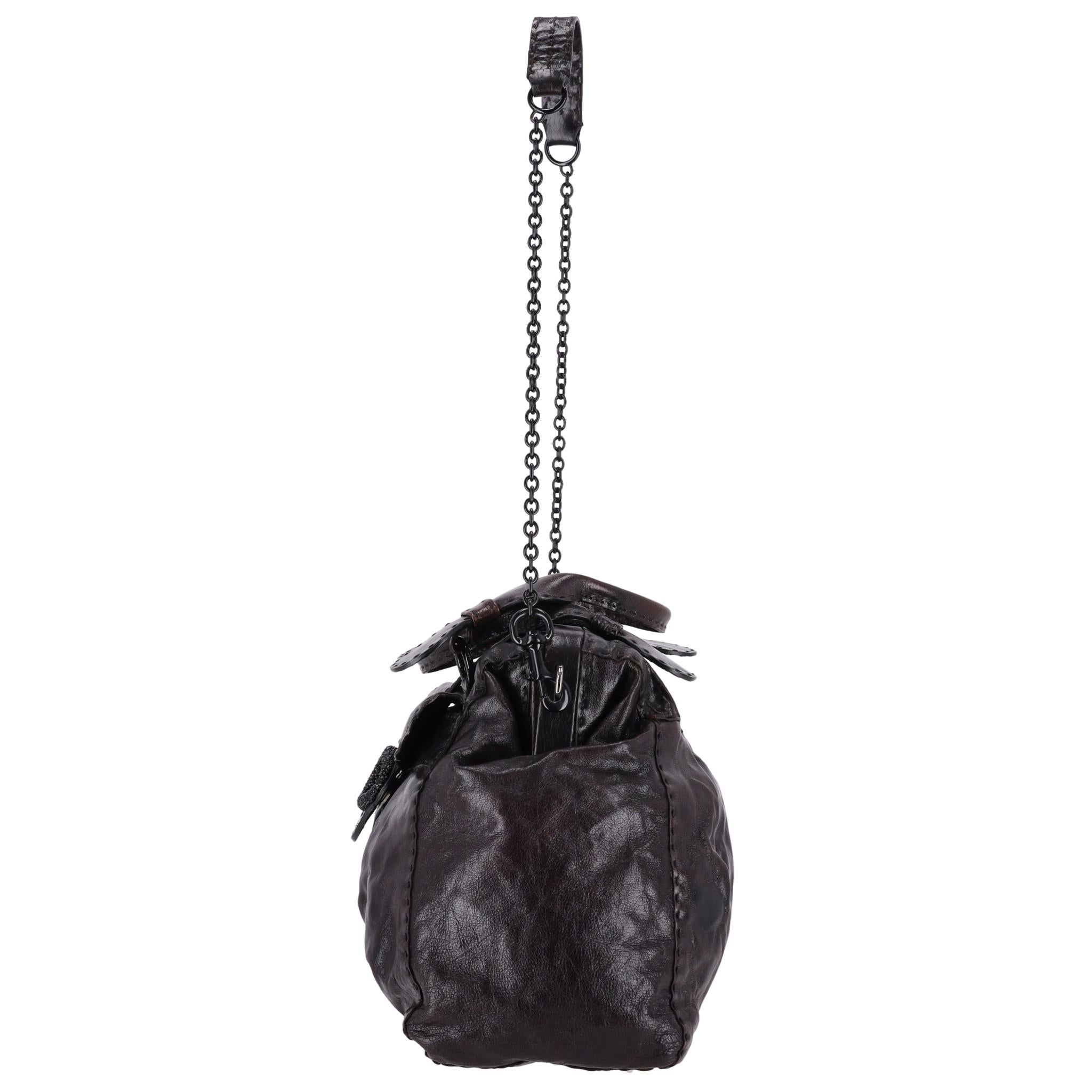 Valentino Garavani Crystal Embellished 'V' Logo Leather Bag

Dark brown hand/shoulder bag with signature 'V' logo to the front encrusted with black crystals.

Pleated design to the body with tonal stitching and black hardware.

Dual rolled top