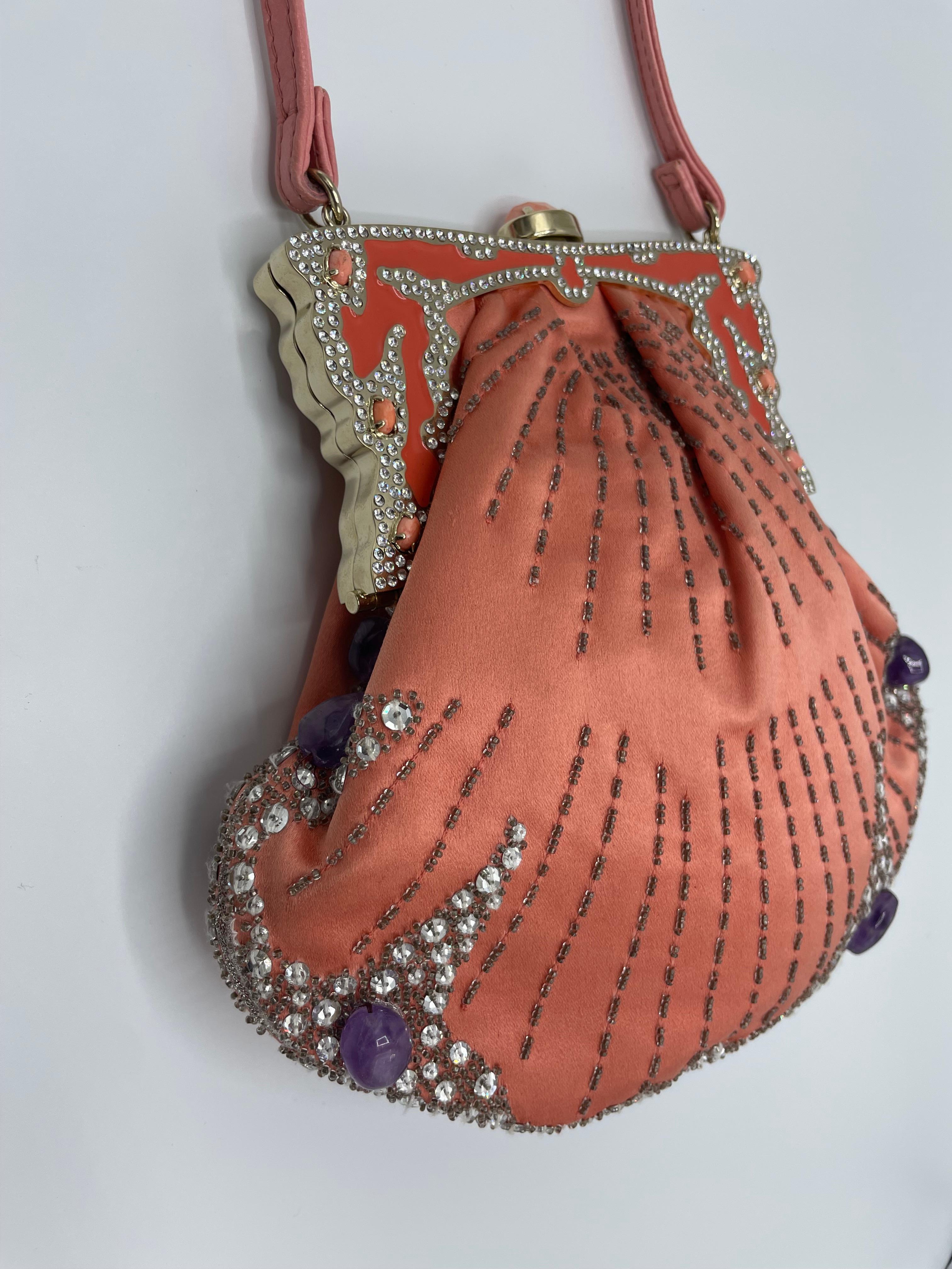 Perfekter Zustand für diese VALENTINO Garavani Abendtasche. Diese rosafarbene Satintasche ist mit Strasssteinen und Amethystperlen bestickt. Der Verschluss der Tasche ist mit rosa Perlen und Strasssteinen besetzt. Ein feiner rosa Lederriemen
