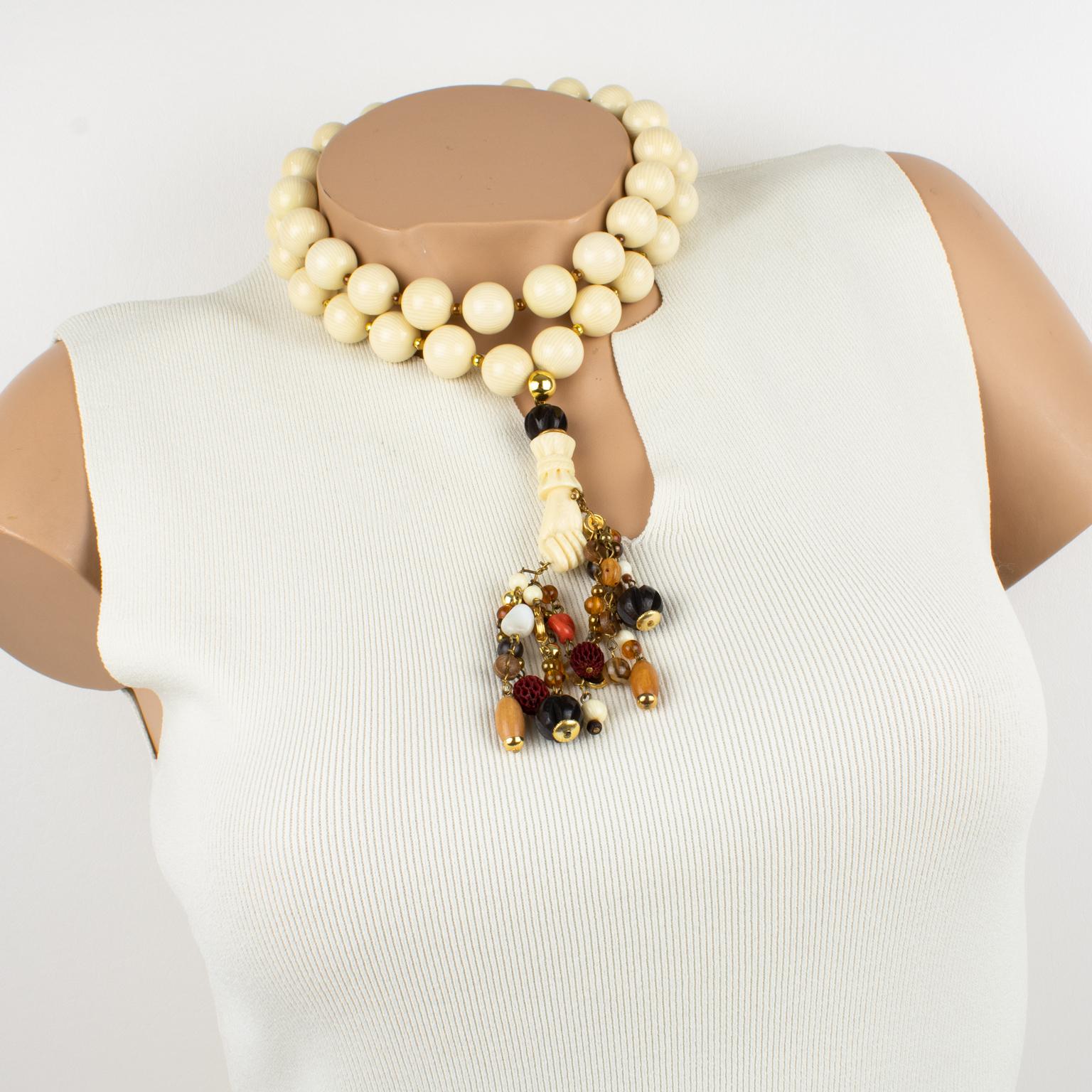 Ce fabuleux collier ras-de-cou Valentino Garavani Haute Couture se compose d'un double fil épais de grosses perles en résine blanc cassé à motif texturé faux ivoire, complété par un long pendentif surdimensionné. Le pendentif représente une main