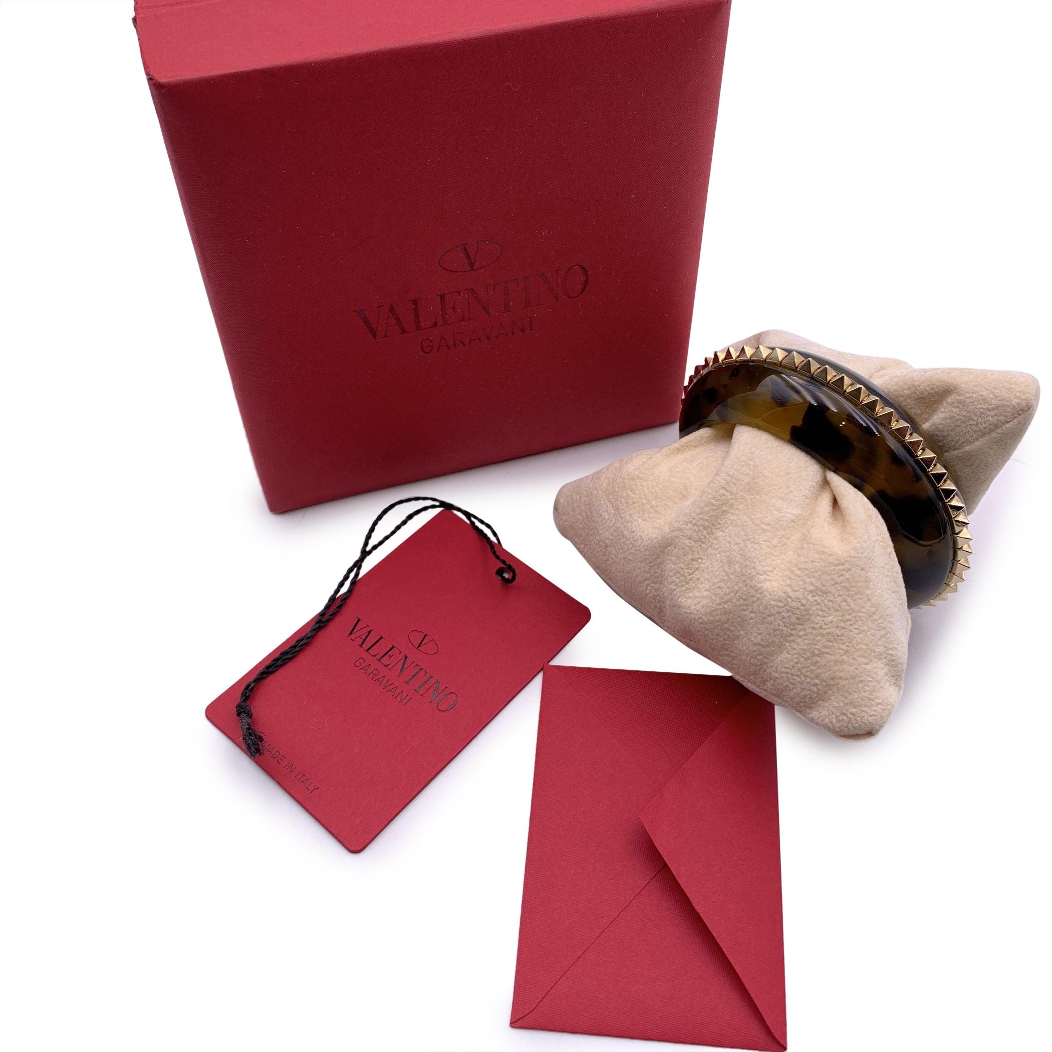 Valentino Garavani havana plastic cuff bracelet. The bracelet features gold metal spike studs in the center. Open design. Internal circumference: 6 inches - 15.2 cm Condition A - EXCELLENT Gently used. Please check pictures carefully and ask for any