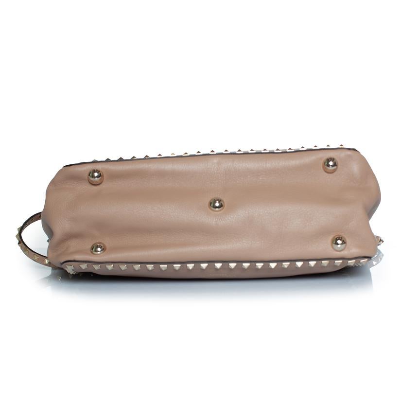 Valentino Garavani, cabas moyen en cuir rockstud en beige. L'article est en très bon état avec quelques petites bosses et rayures sur le cuir. L'article est livré avec une bandoulière et un sac à poussière. Très petite décoloration sur l'un des