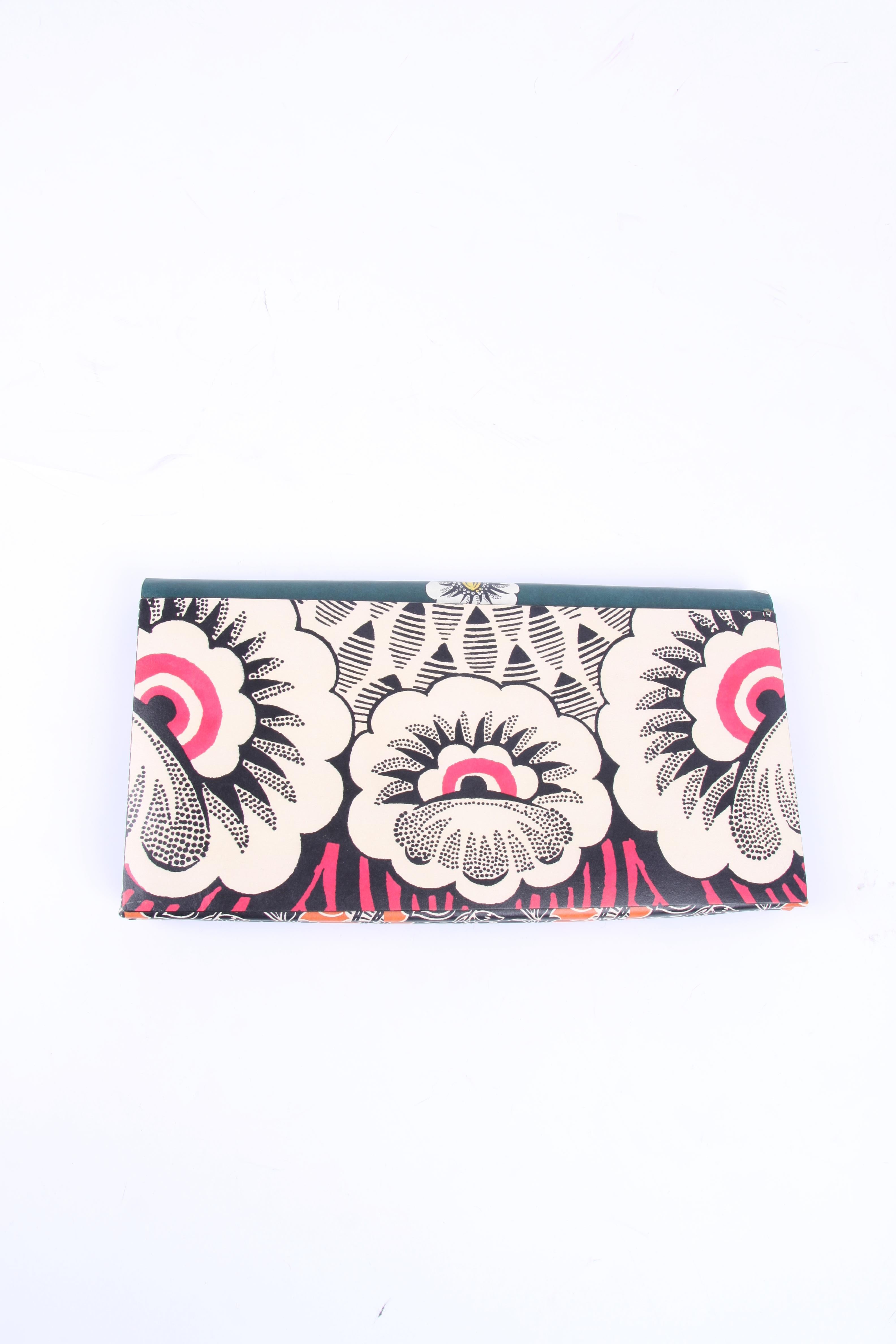 Neat XL clutch by Valentino Garavani wearing the name MIME Floral Print Clutch Bag. 

Eye-catching colors as green, pink, orange, yellow, white and black are used for the print. Front push-lock closure, of course embellished with the famous